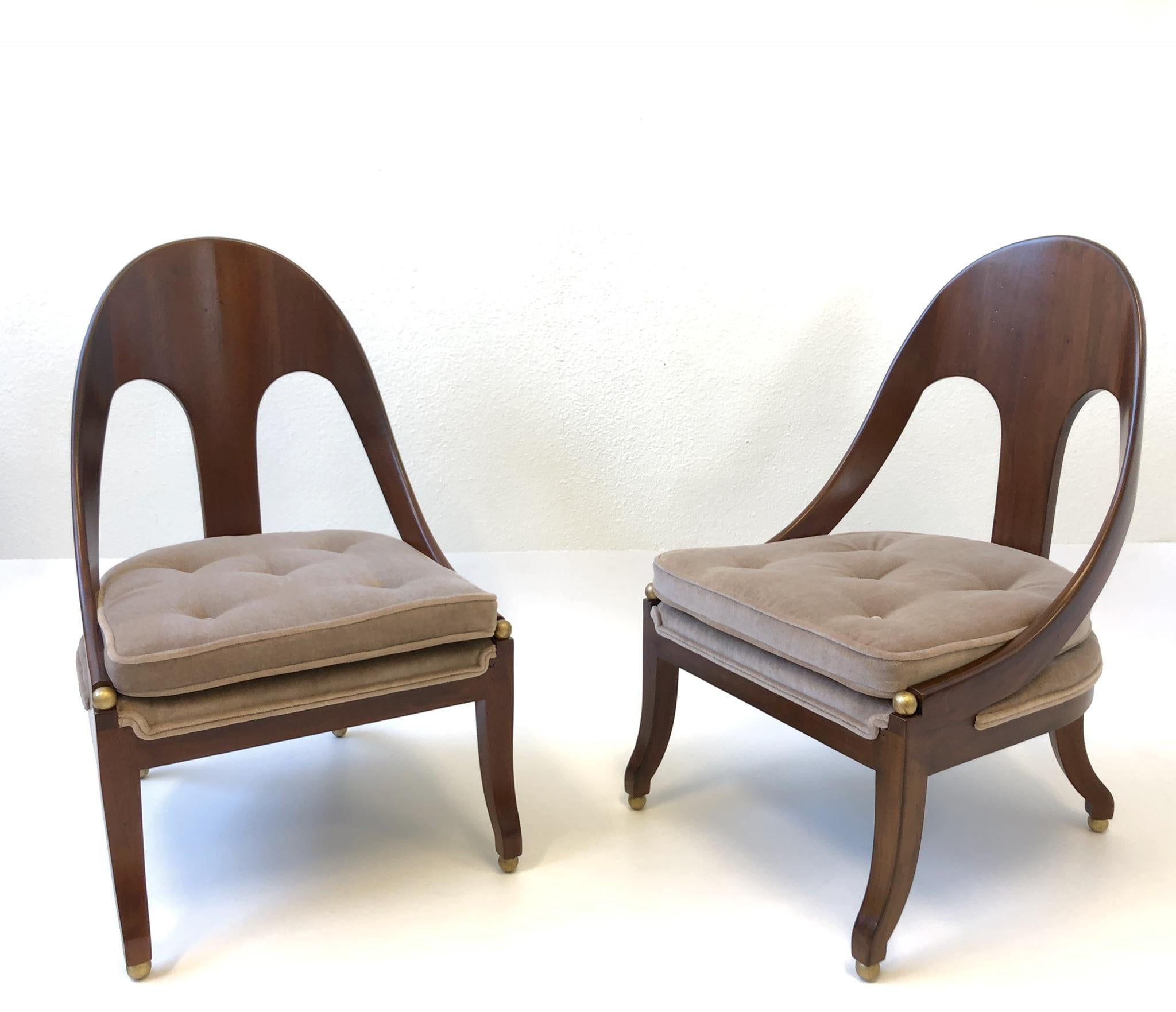 A spectacular pair of 1950s solid mahogany spoon back lounge chairs by renowned designer Michael Taylor for Baker Furniture Co. The spheres are gilded. Newly reupholstered in a soft light brown with a hint of blush mohair fabric. If you need a