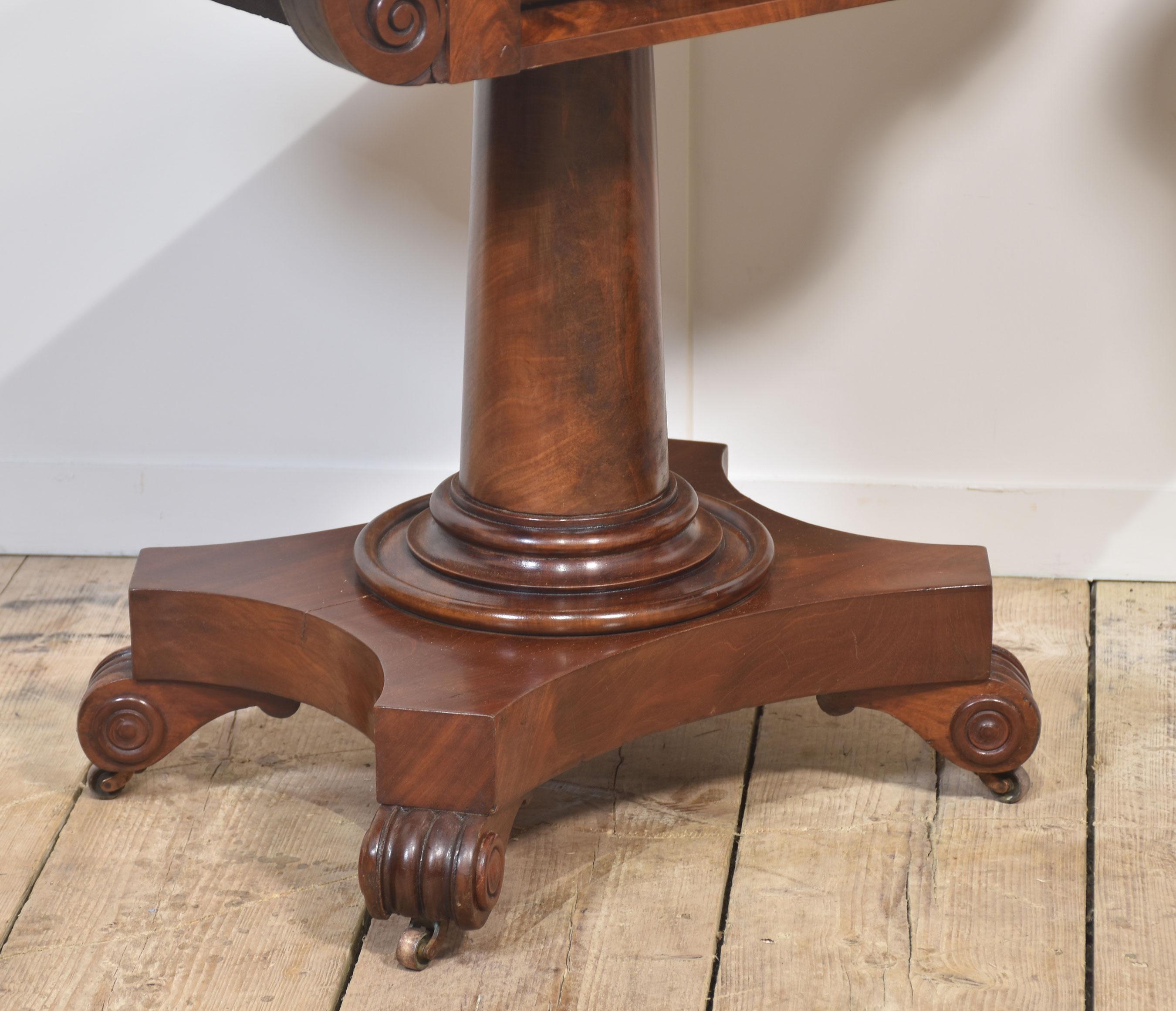 Un par de mesas de té con pedestal de caoba Guillermo IV, con tableros de caoba maciza flameada y bien configurados, que se abren para revelar una gran superficie de comedor, sobre la que se apoya un pie circular con patas en volutas y ruedas de