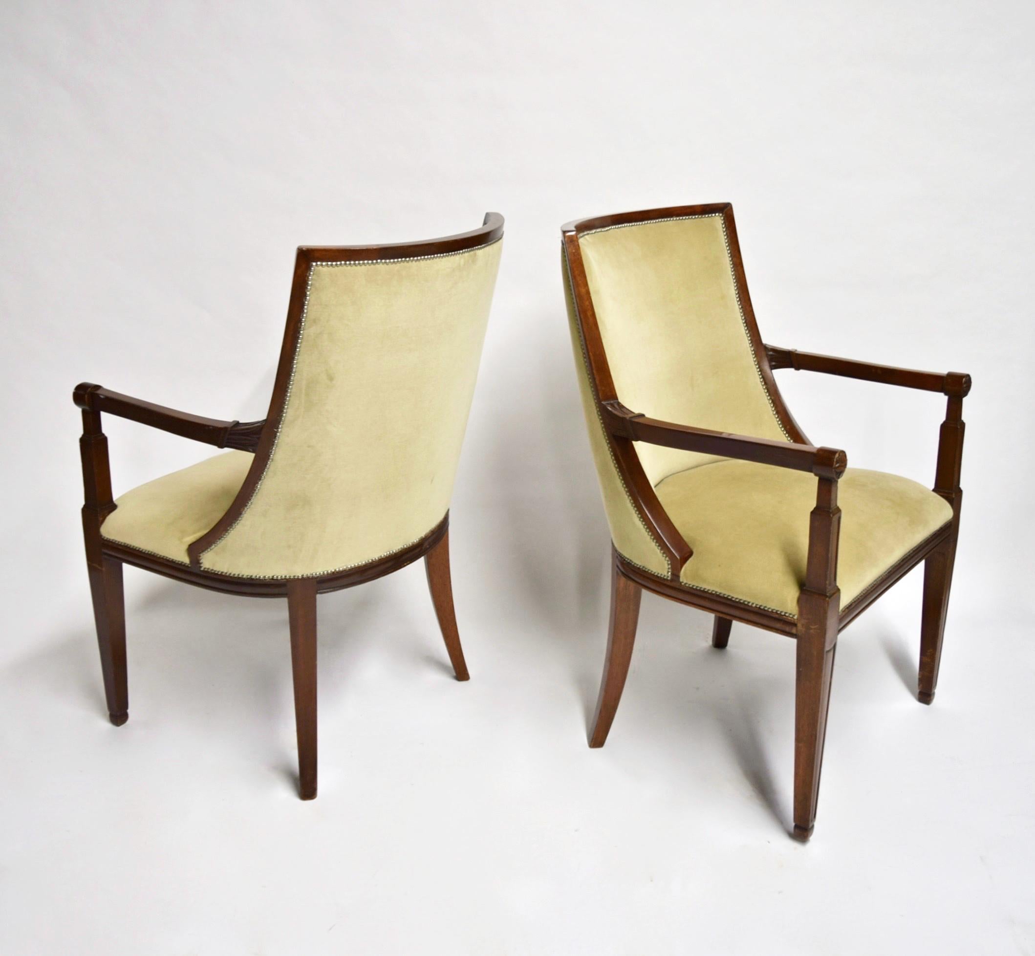 Pair of French Directoire style armchairs in quality mahogany wood with paterae and hand carved details on the arms, an elegant gondola back, arched back legs, and beige mohair velvet upholstery with the nickel plated nailheads. Arm height: 65.5 cm