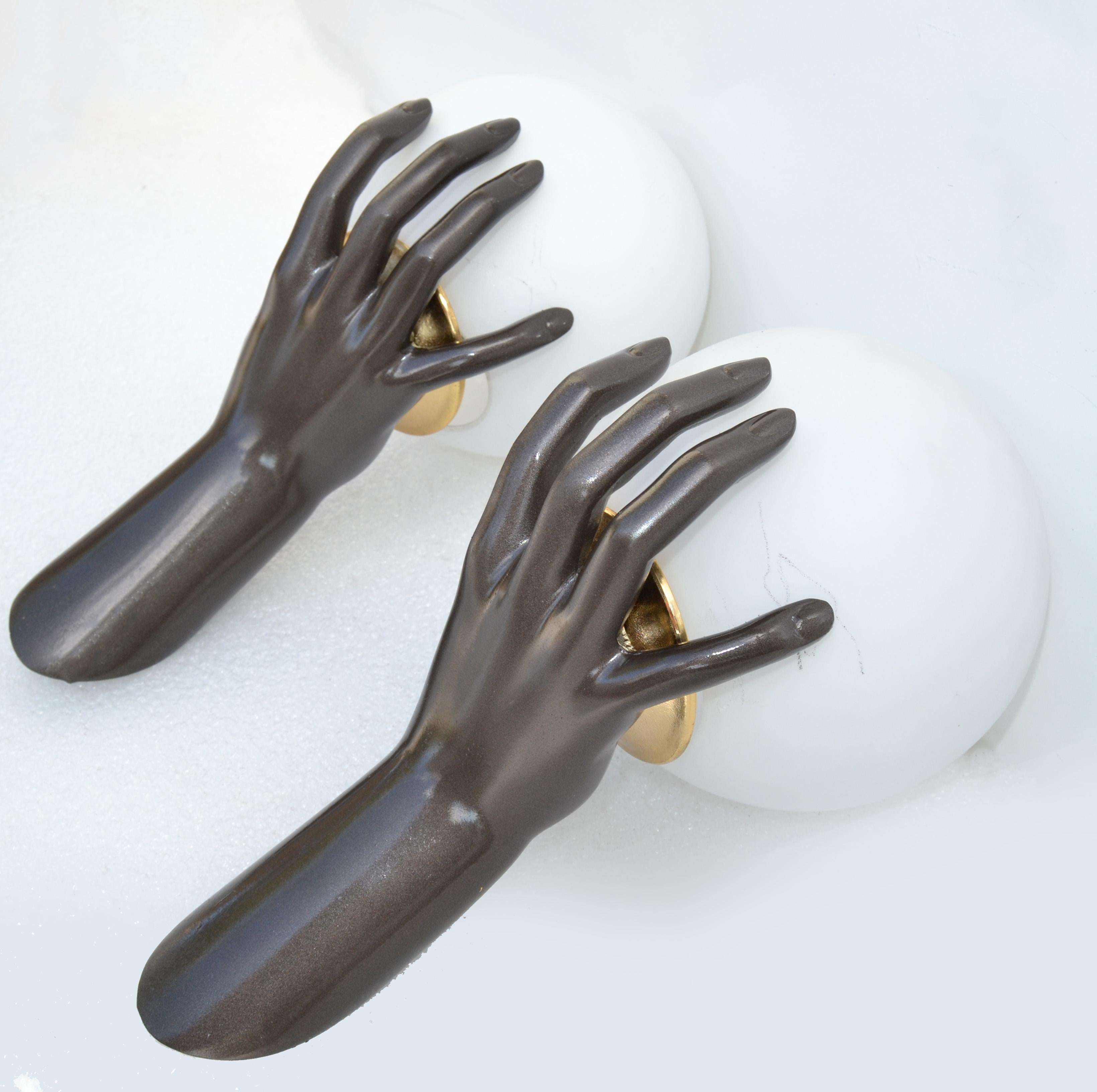 Superb bronze color pair of hands sconces by Maison Arlus. Model number 1436, figuring a bronze hand holding a lighted Opaline Globe.
US rewired and in working condition each hand takes one light bulb, 60 watts max. 
Measurement: round opaline