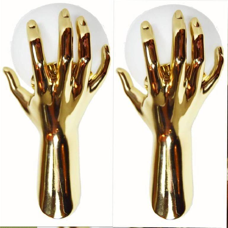 Fantastic and documented pair of sconces by Maison Arlus, figuring a gold Hand holding an opaline glass globe Provenance: Parisian hotel (Rive Gauche) US wired and in working condition. 4 pairs available.
            