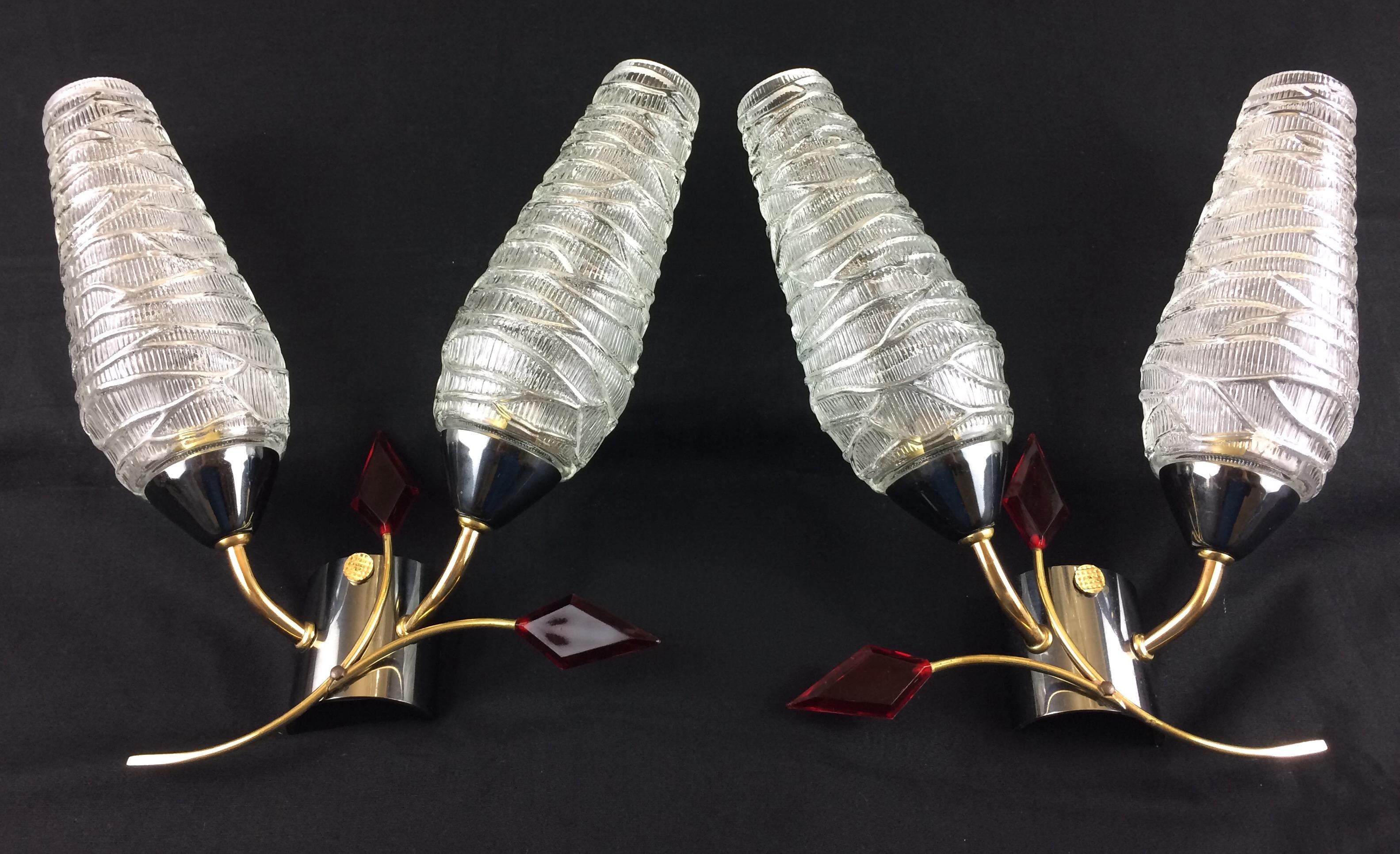 An elegant pair of midcentury wall sconces by Maison Arlus, 1950s-1960s, France.

These midcentury modern, 1950s-1960s originals feature two conical glass shades mounted on an asymmetrical curved double brass structure with charming ruby red lucite