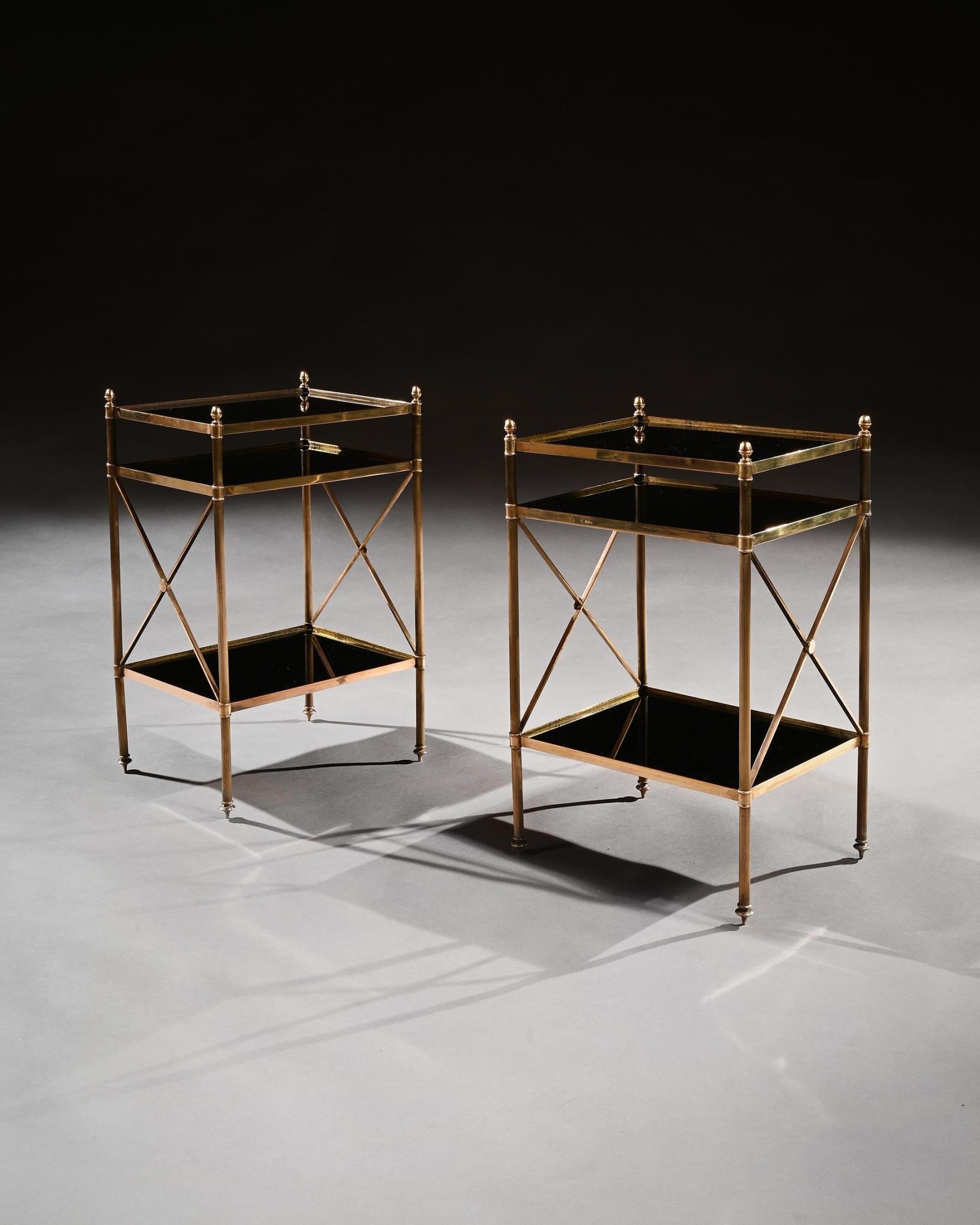 A stylish pair of brass and black glass etagere / side tables in the Louis XVI style attributed to Maison Baguès.



French Circa 1940’s



Having acorn finials and three black glass tiers, supported by reeded tubular supports with x-frame