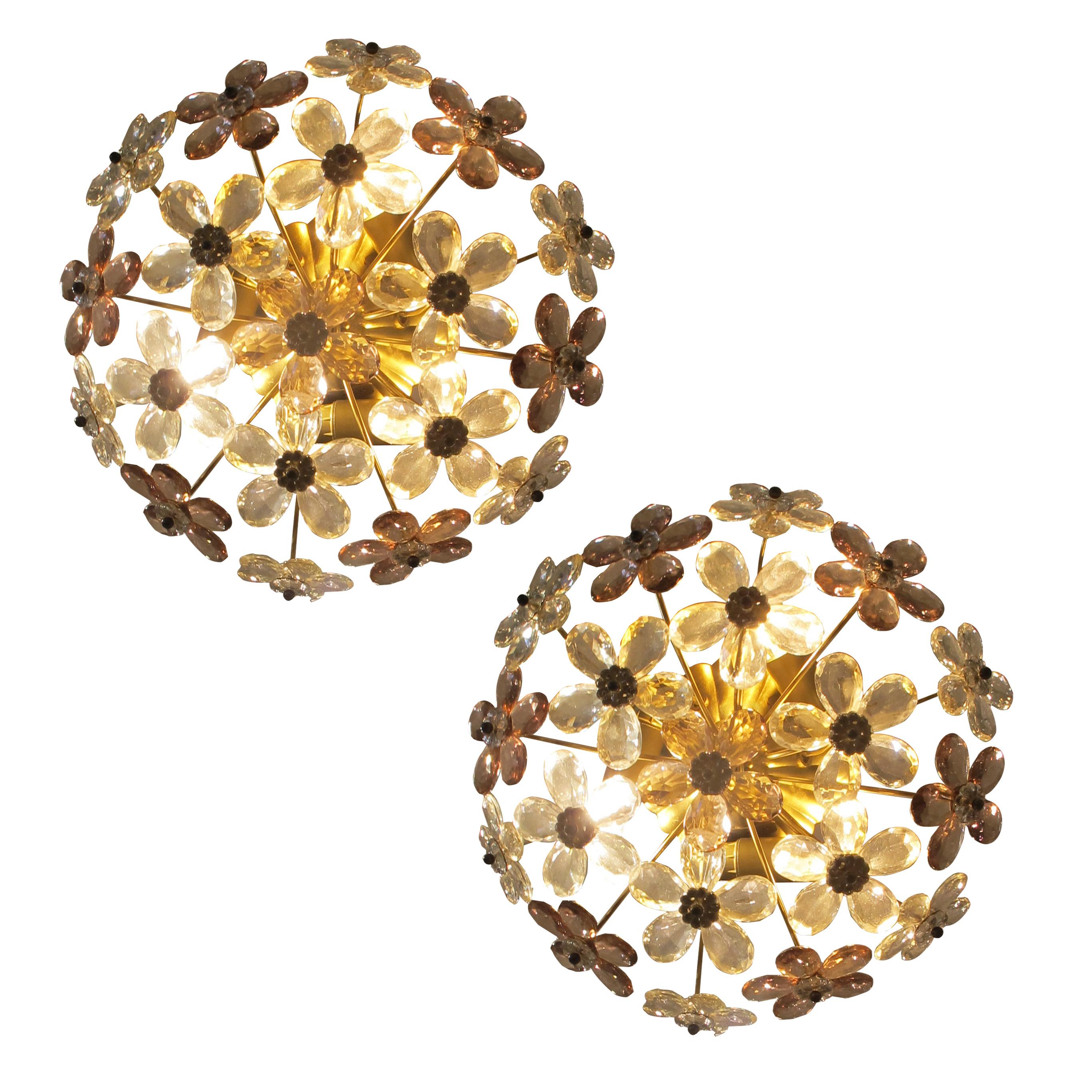 A pair of vintage French ceiling lights from the 1970s by Maison Baguess, each designed with brass fittings and decorated with crystal glass flowers in clear and pale amethyst tones. The faceted petals catch the light beautifully, giving a warm and