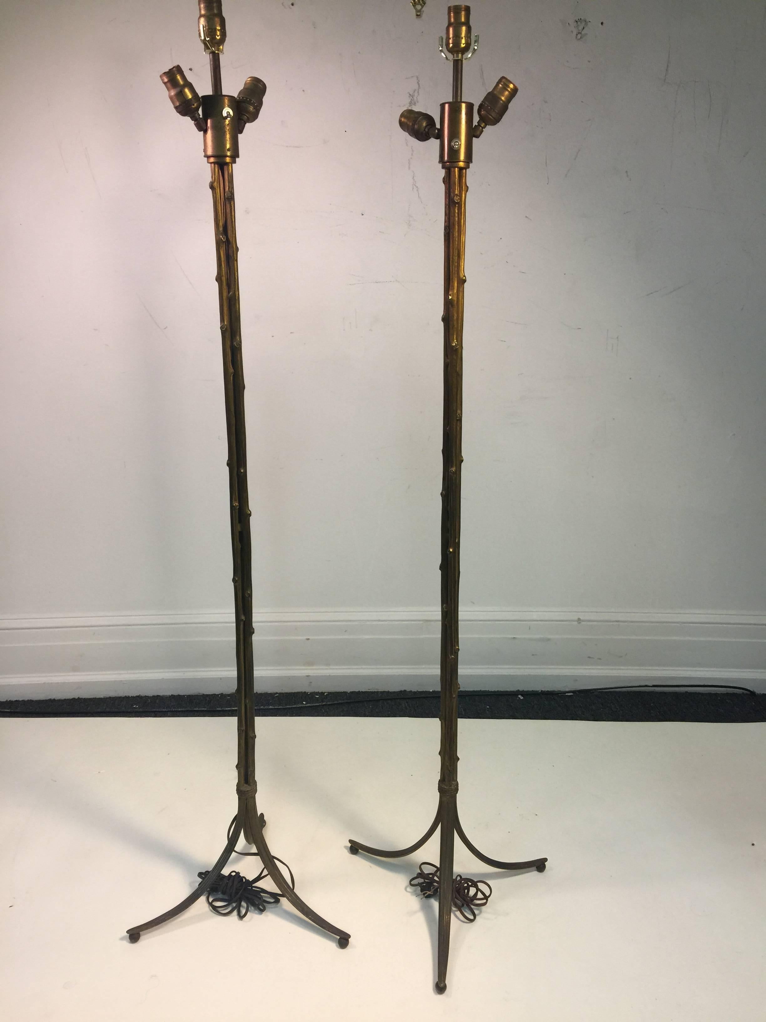 Pair of 1930s-1940s gilt bronze bamboo floor lamps with three sockets designed by French firm Maison Baguès. Beautifully cast and designed as a bundle of bamboo with a tripod base with a wrapped rope design at the base. The gilt finish is worn as in