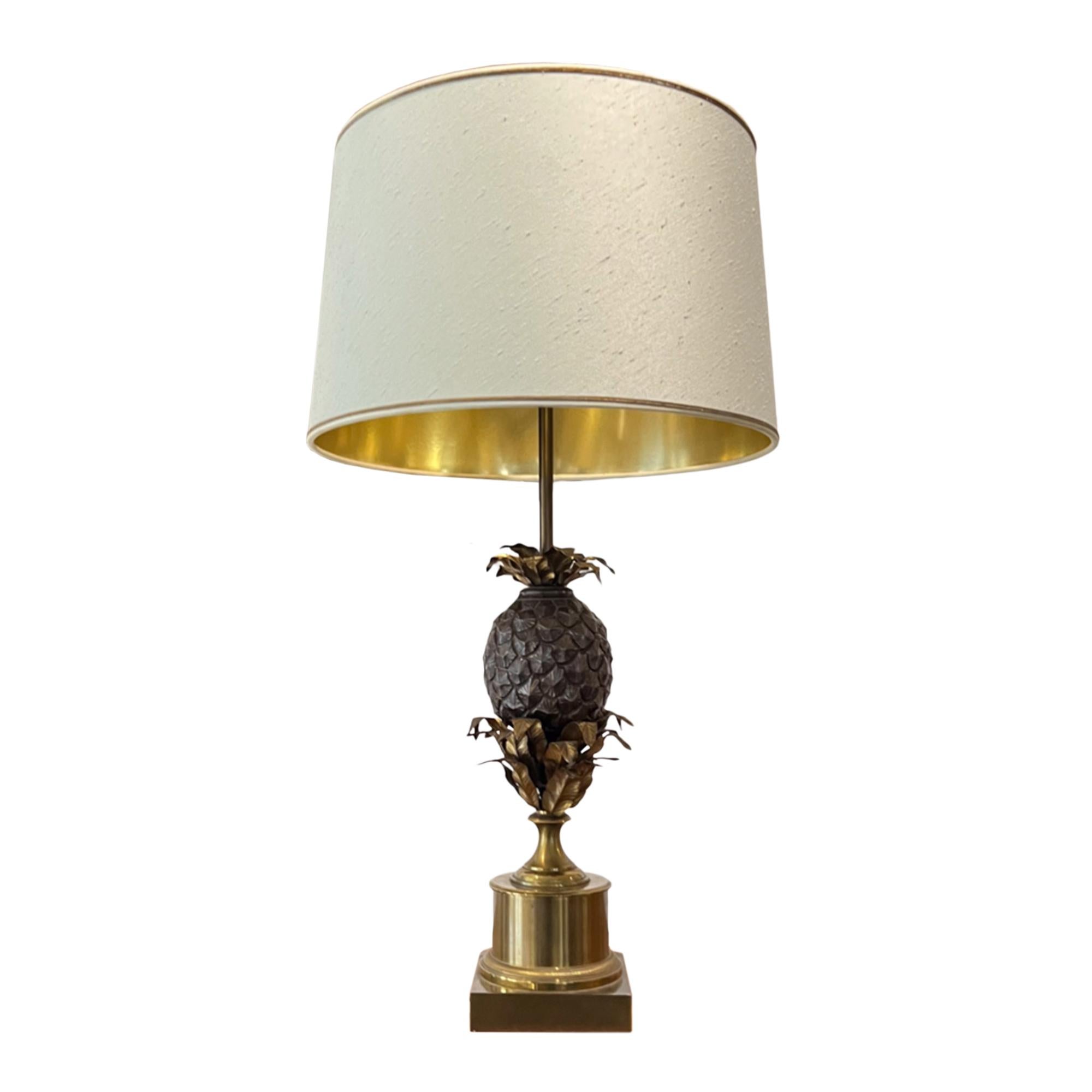 This pair of Maison Charles pineapple lamps are made from brass and metal with the original fabric shades. 

These lights decorated with the Charles' brothers iconic pineapples have 3 bulbs each and have been rewired with rope twisted flex. They