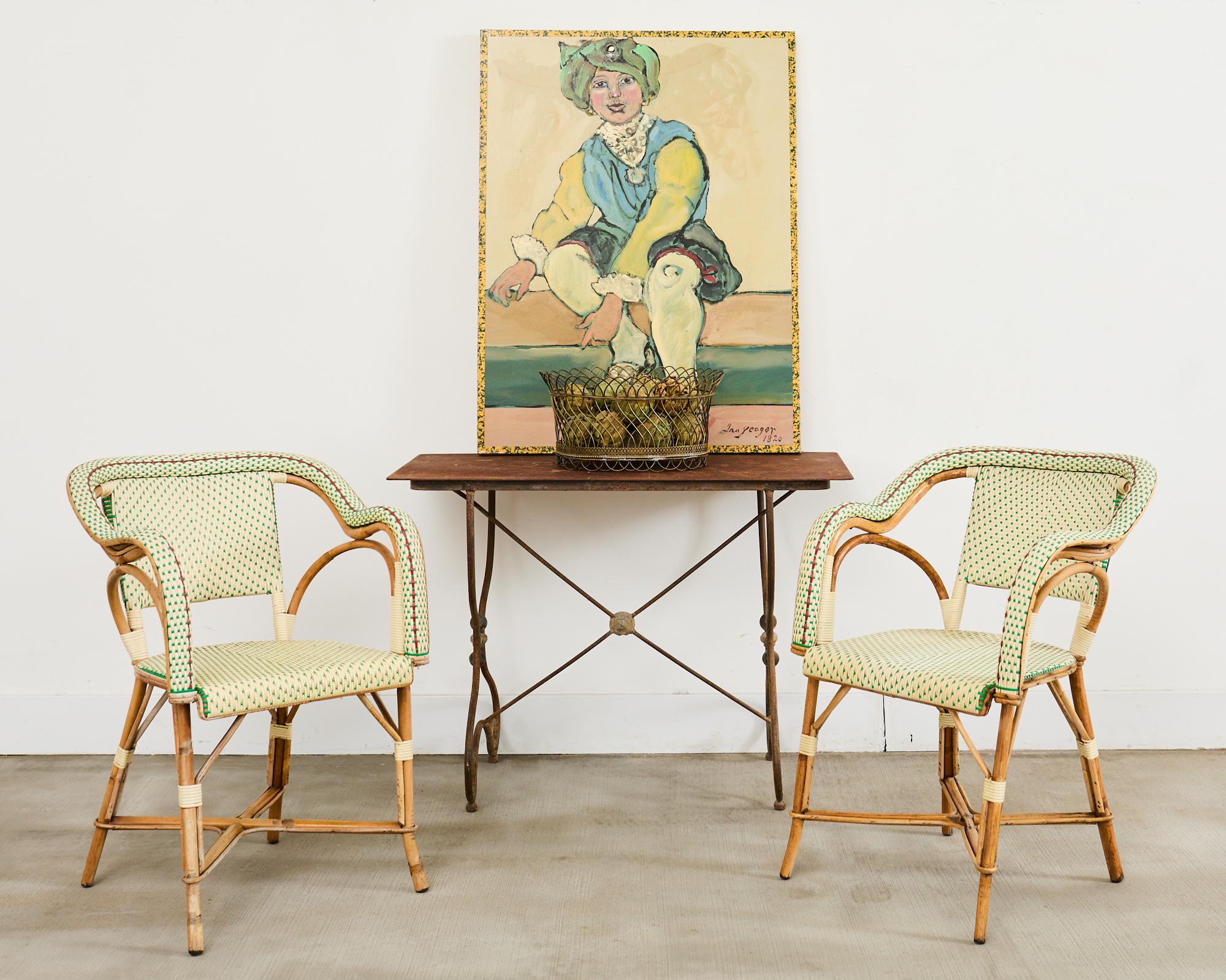 Skurriles Paar Bistro-Café-Rattan-Esssessel im Art-déco-Stil von Maison Gatti Paris, Frankreich. Die Stühle haben anmutig geschwungene oder gebogene Rattangestelle. Die Armlehnen und der Sitz sind mit buntem Harzgeflecht verziert. Das Design