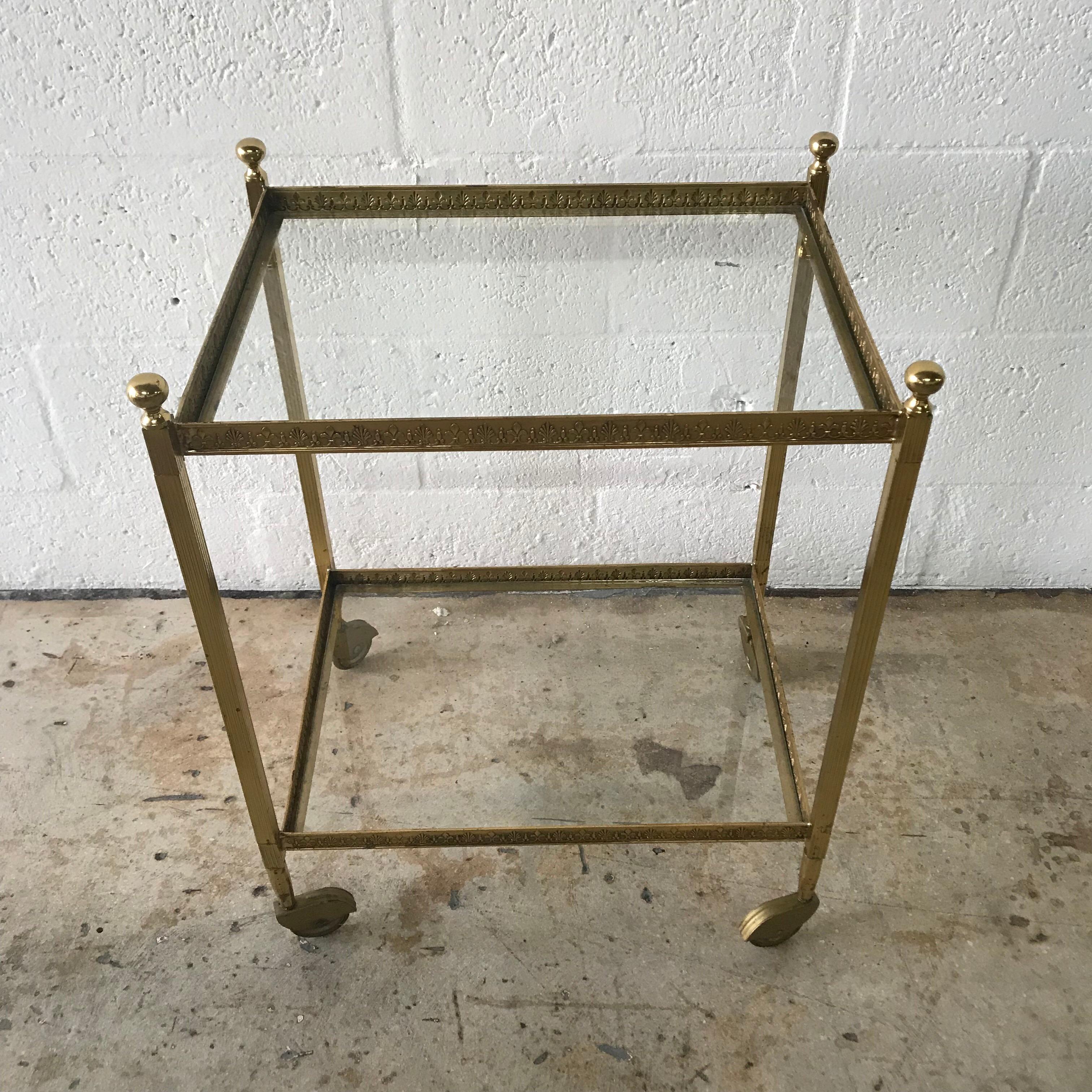 Two tier rolling occasional tables or cart rendered in brass and glass by Maison Jansen

One table is 25