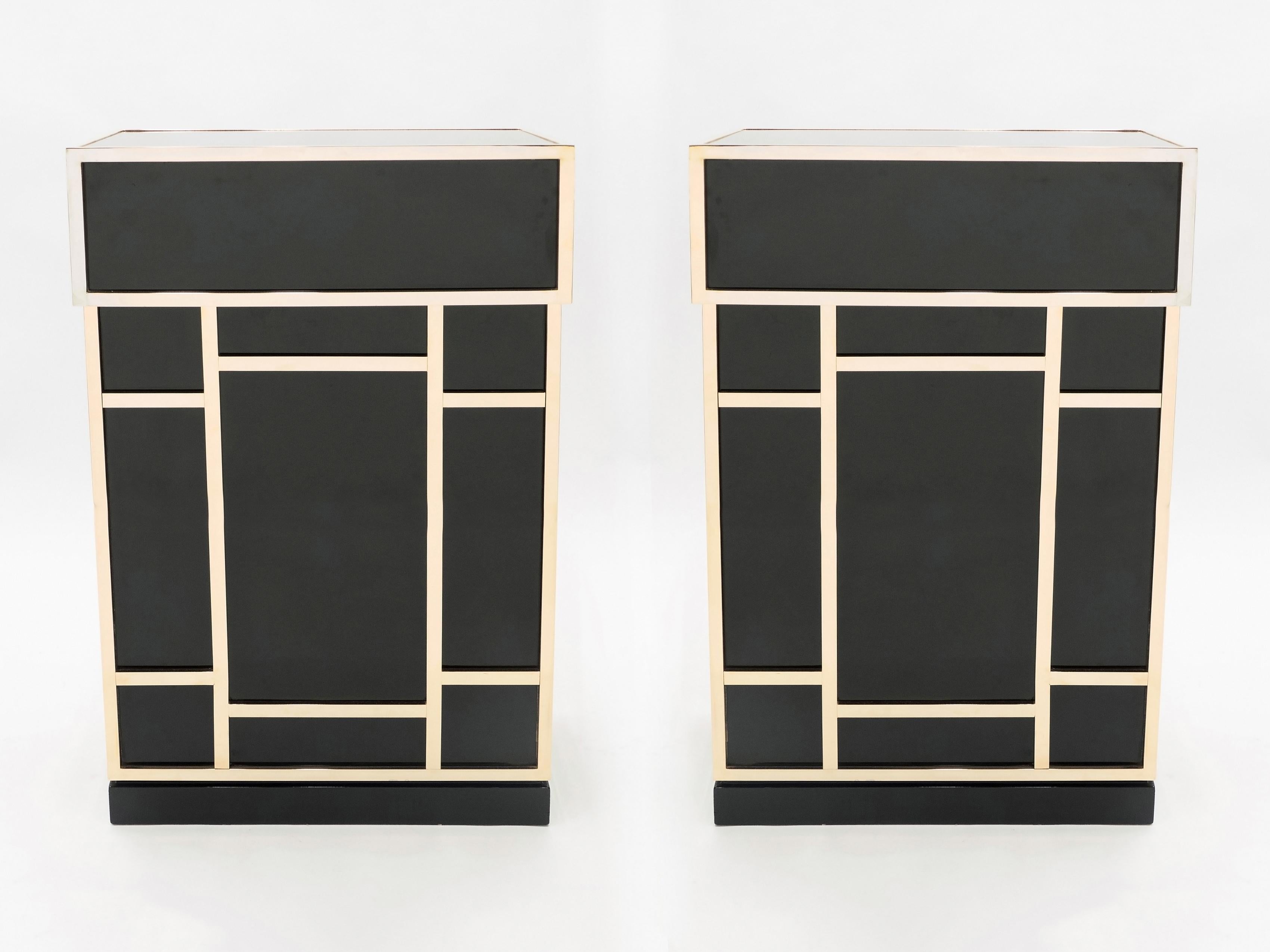 Timeless vintage pieces, this pair of mid-century dry bar elements feel imposing and glamourous, with thick, straight lines of brass adorning its exterior of reflective black lacquer. Glossy black lacquer, paired with bright brass accents, feels