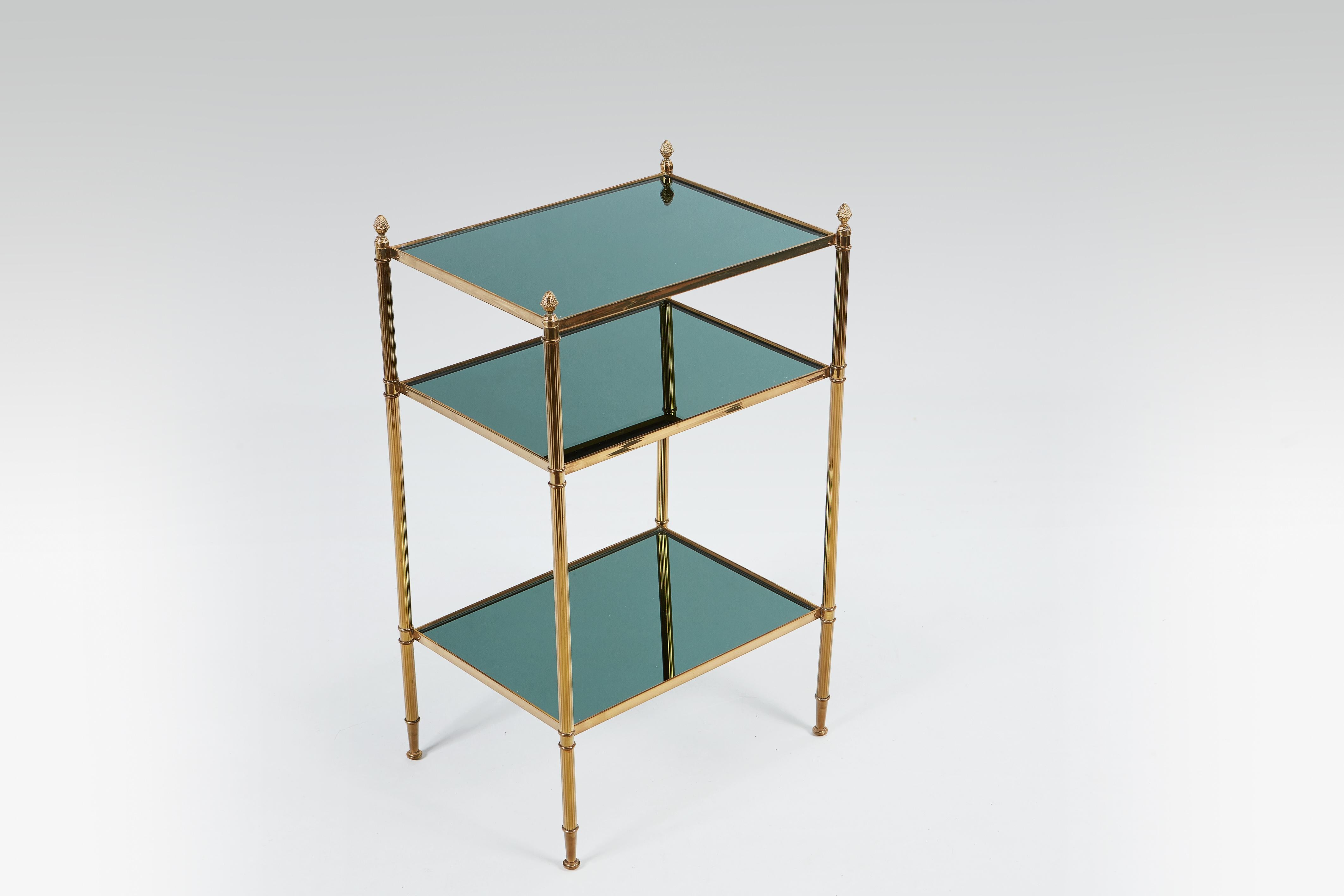 Beautiful pair of 1960s elegant Maison Jansen, attributed, rectangular end tables in gilded brass with three coloured, phthalo green, glass banded shelves resting on four fluted columns topped with stylized acorns. In very good condition and