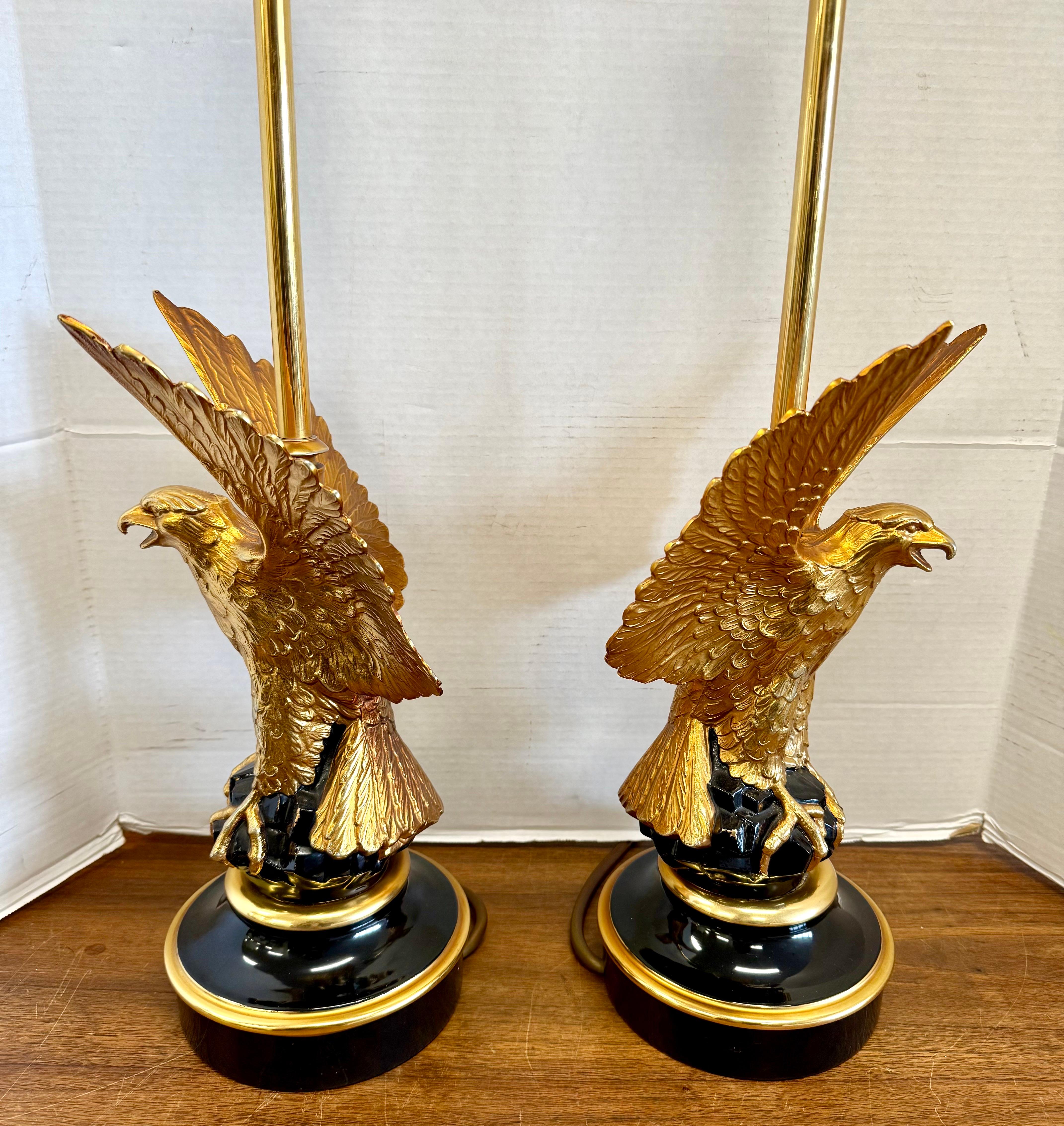 Diese auffälligen Tischlampen zeigen einen Adler aus vergoldeter Bronze mit ausgebreiteten Flügeln, der auf einem schwarz lackierten Sockel mit eleganten goldenen Akzenten thront und für dramatische Effekte sorgt.  Maison Jansen ist berühmt für