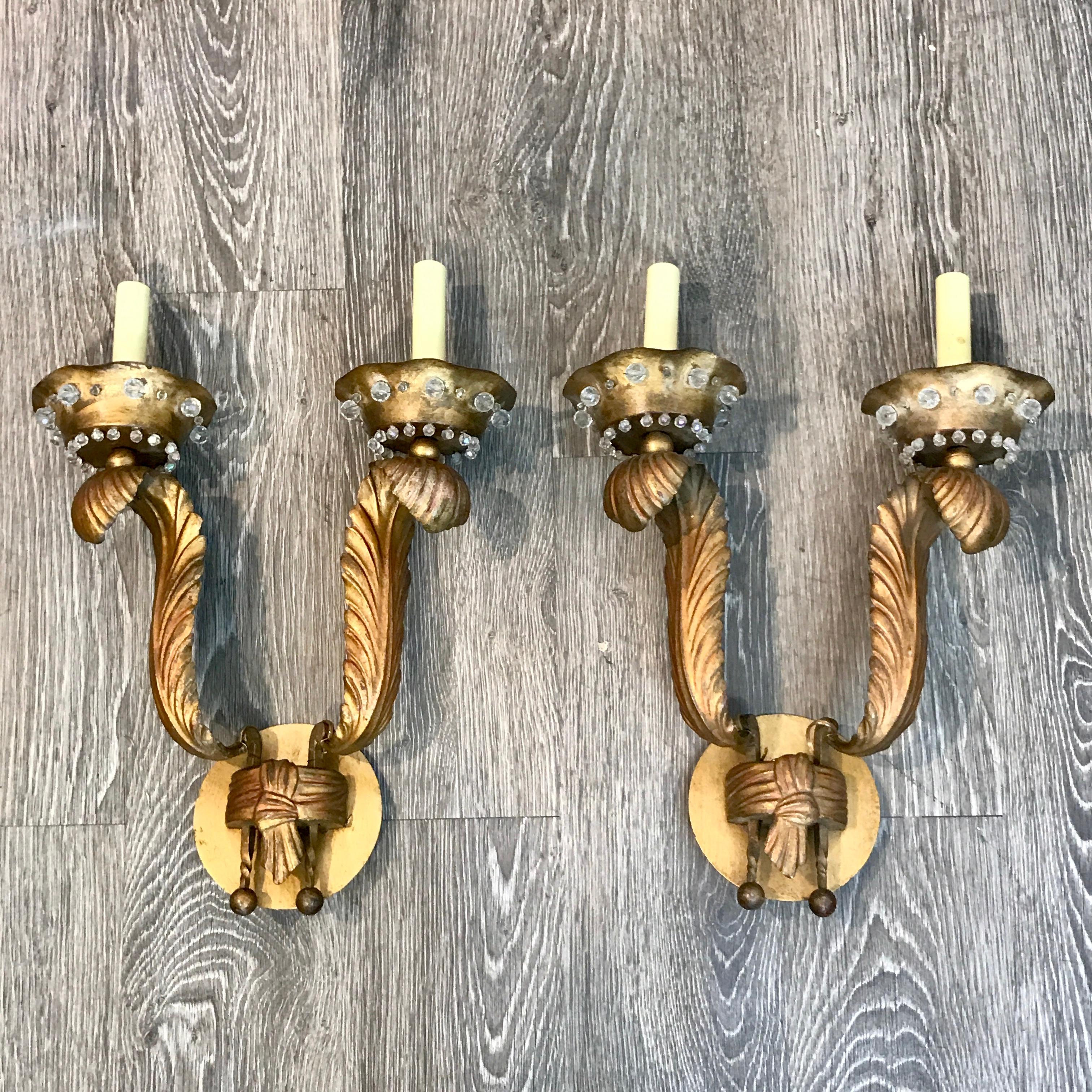 Pair of Maison Jansen gilt feather motif wall sconces, each one with fitted with two lights with crystal encrusted bobeches.