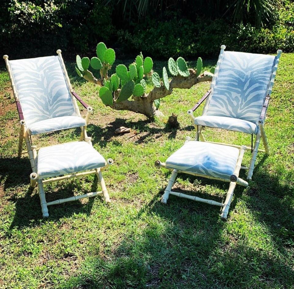 Elegant pair of Maison Jansen style folding chairs with matching folding benches. This wonderful pair of Camping Chairs are Faux Bamboo carved mahogany with original antiqued ivory finish. The reclining of the chairs can be adjusted by the leather