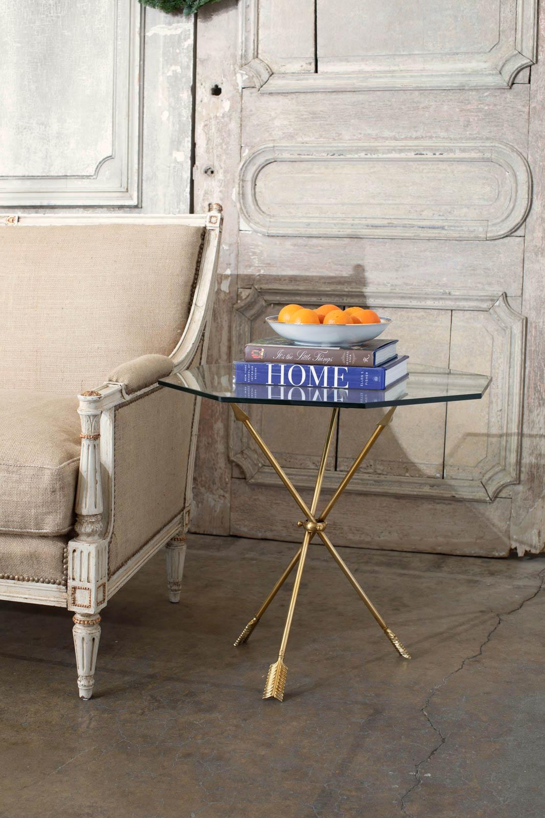 Stunning pair of brass directore neoclassical style arrow tripod tables made in the manner and style of Maison Jansen. Beautifully crafted with impressive detail and topped with octagonal shaped panes of glass. Each set of three arrows is conjoined