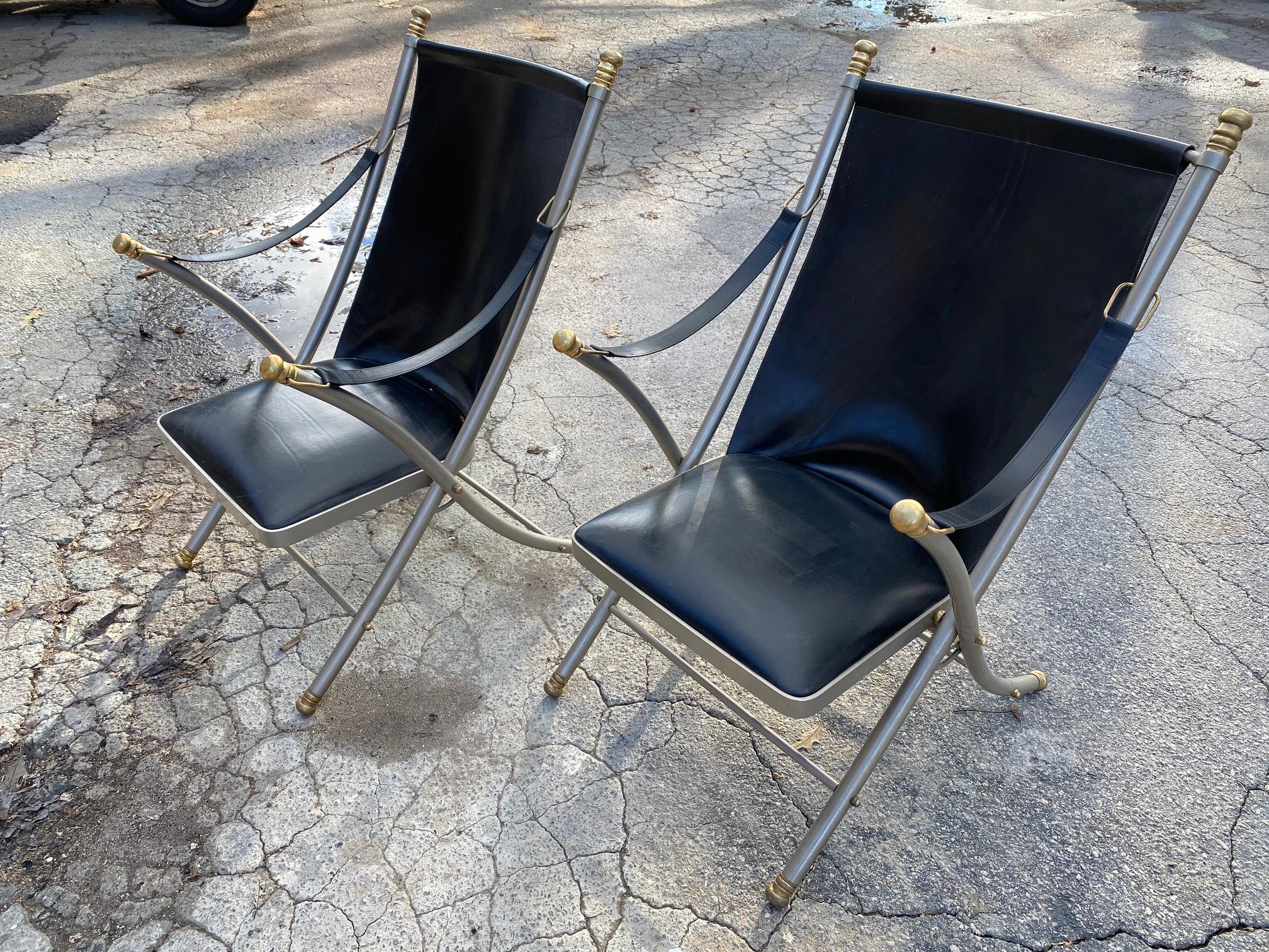 Lovely pair of Maison Jansen style midcentury chairs made of steel and brass upholstered in black leather. These fine looking chairs are transitional and would work well in a variety of decors.