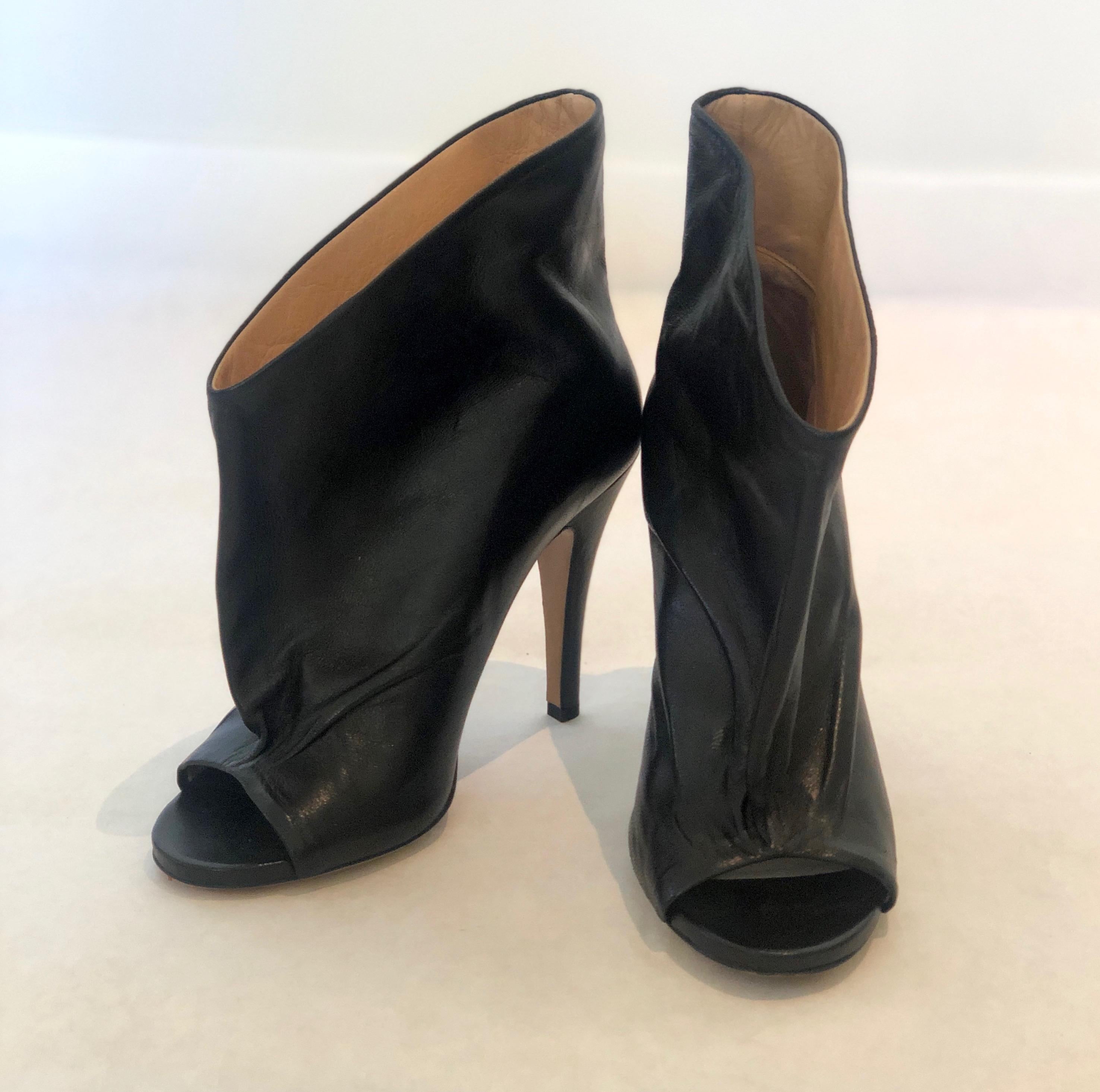 Make:  Maison Martin Margiala
Place of Manufacture:  Paris
Size:  39.5 EU / 9.5 U.S.
Materials:  Leather
Color:  Black exterior with tan leather interior
Style:  Open toe ankle boots / bootie with 4