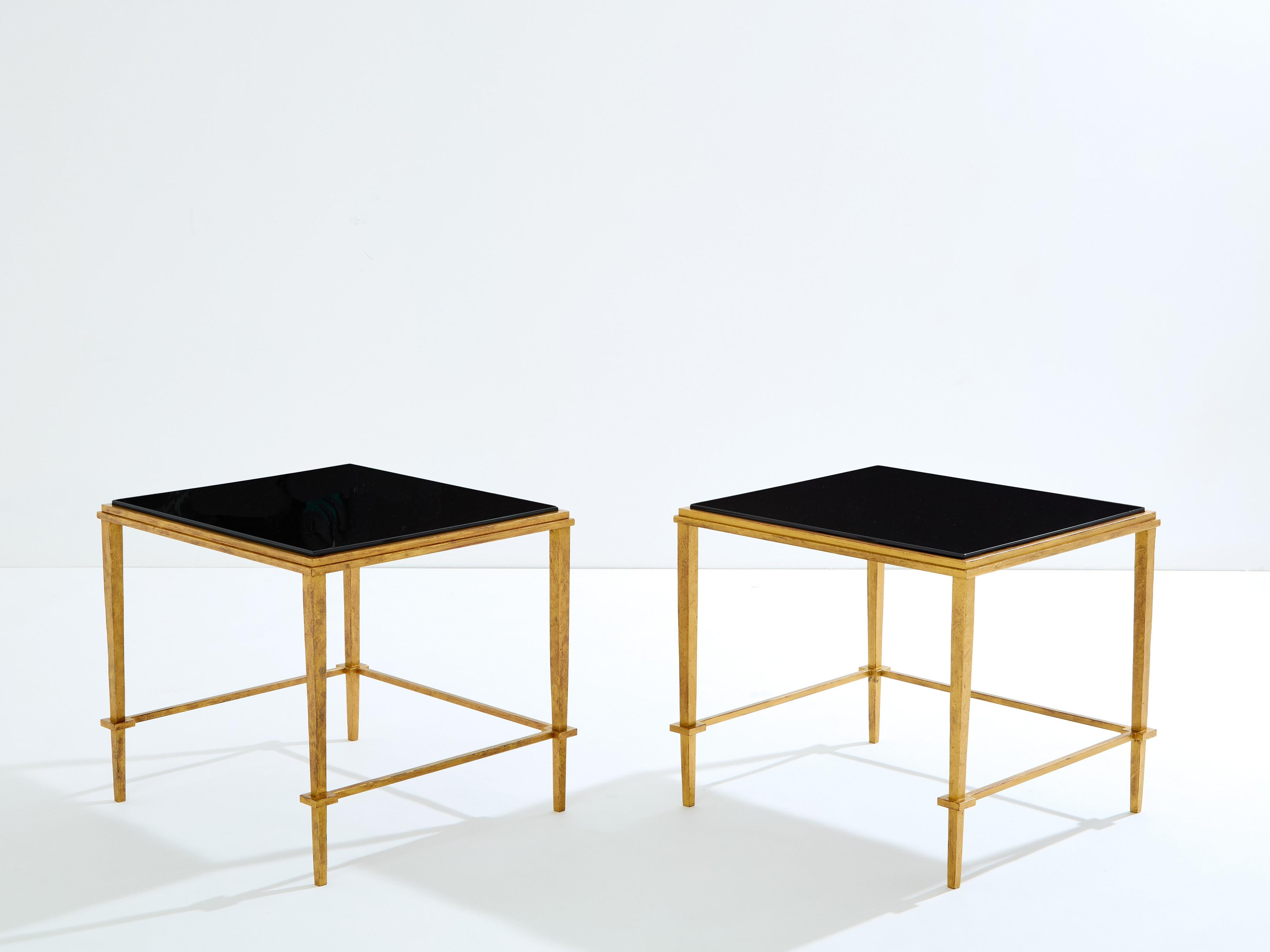 Dieses schöne Paar Beistelltische von Maison Ramsay stammt aus den späten 1950er Jahren und vermittelt die elegante Stimmung der neoklassischen Post-Art-Deco-Periode. Die schmiedeeisernen Füße glänzen in einer antiken Goldvergoldung, während die