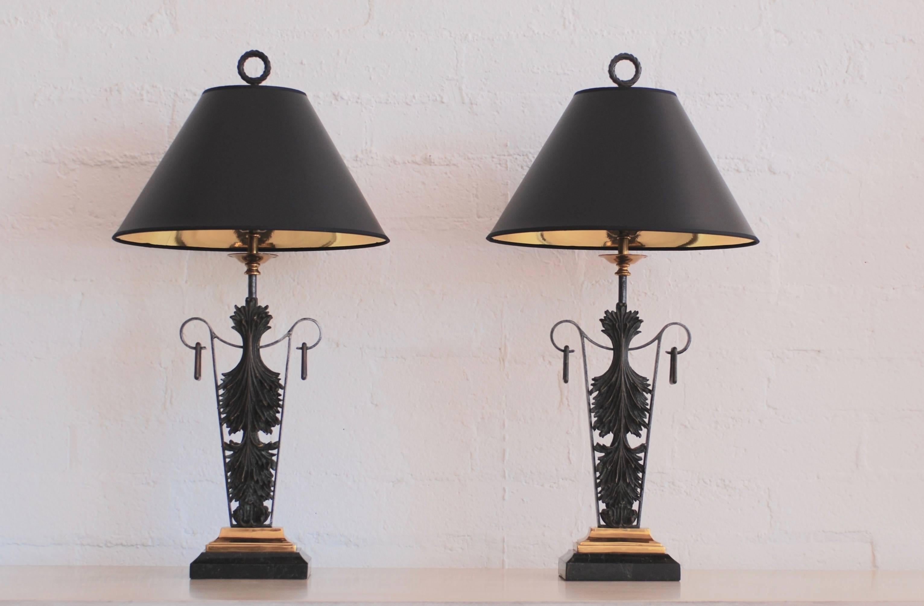 A superb set of bronze neoclassical table lamps by Maitland-Smith set on a brass and dark marble base. These table lamps have graceful classic proportions and come with black paper shades lined with gold interior for a warm glow. The finials are a