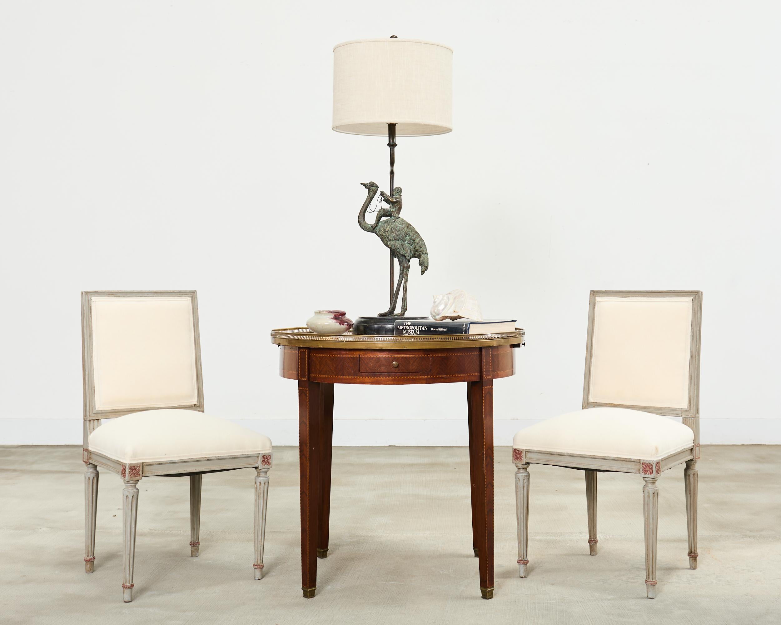 Rare et fantaisiste paire de lampes de table en bronze patiné de Maitland-Smith représentant un singe jockey chevauchant une grande autruche. Les bronzes sont montés sur un socle en pierre tessellée sombre, épais et rond. Les lampes sont très