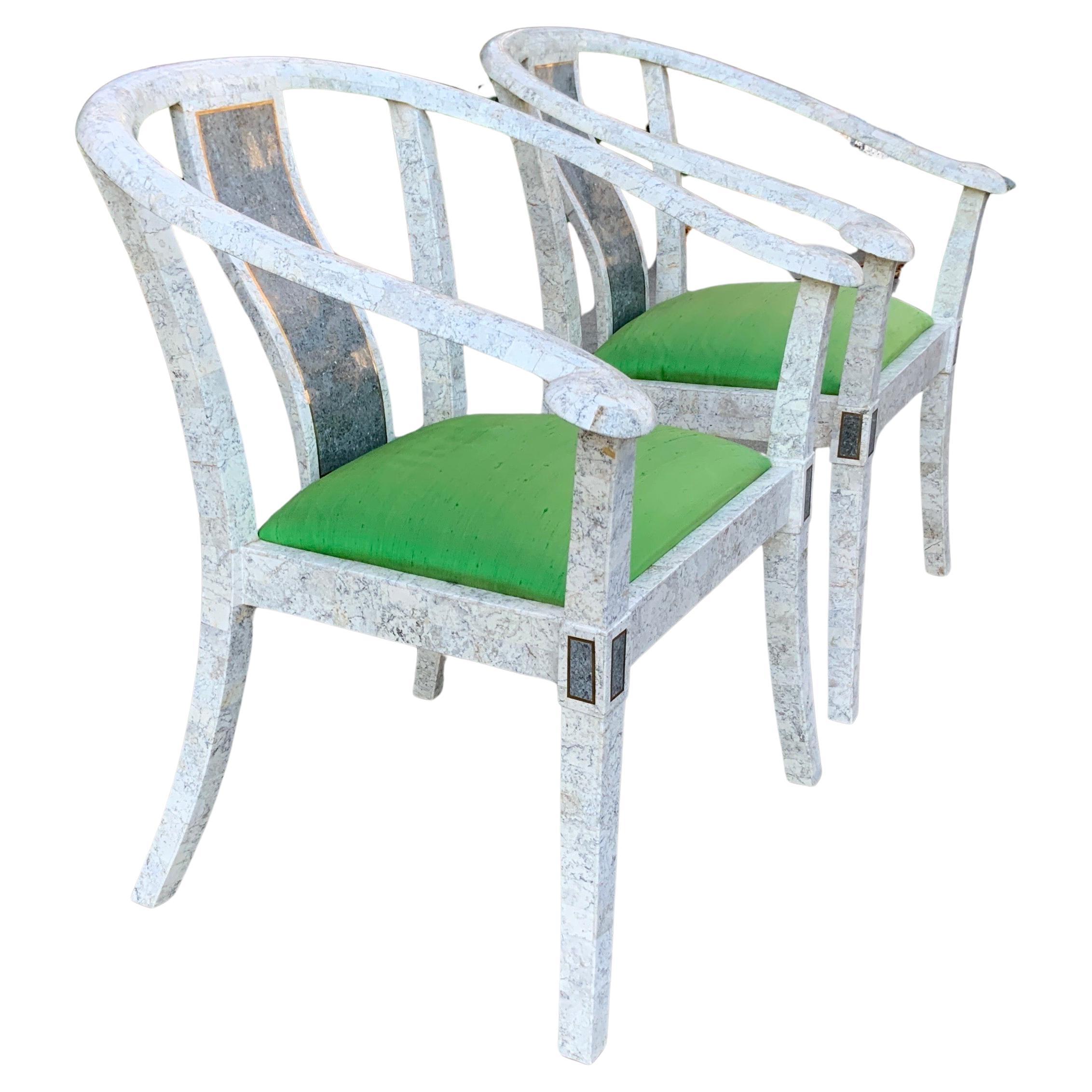 A pair of vintage Maitland Smith tessellated chairs. These beautiful off white stone with green upholstered seats are very sturdy and feature brass inlay and gorgeous green silk covered seats. These impressive chairs with their fantastic design