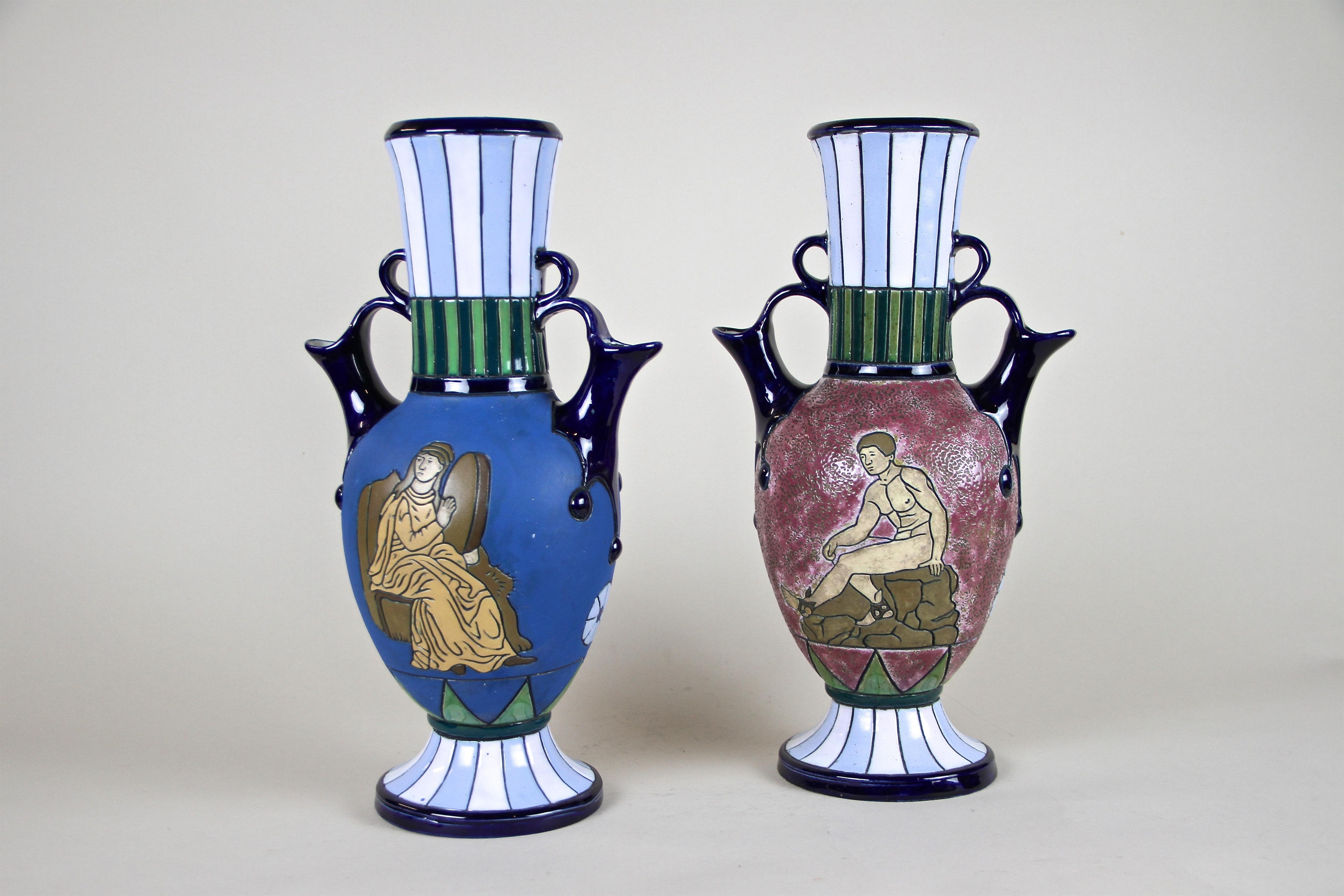 Unusual pair of Majolica Vases handcrafted in the Art Deco period around 1920 by the famous company of Amphora Czechoslovakia. The beautiful amphora-shaped bodies shows a fantastic relief design with great looking polychrome enameled pattern. Eye