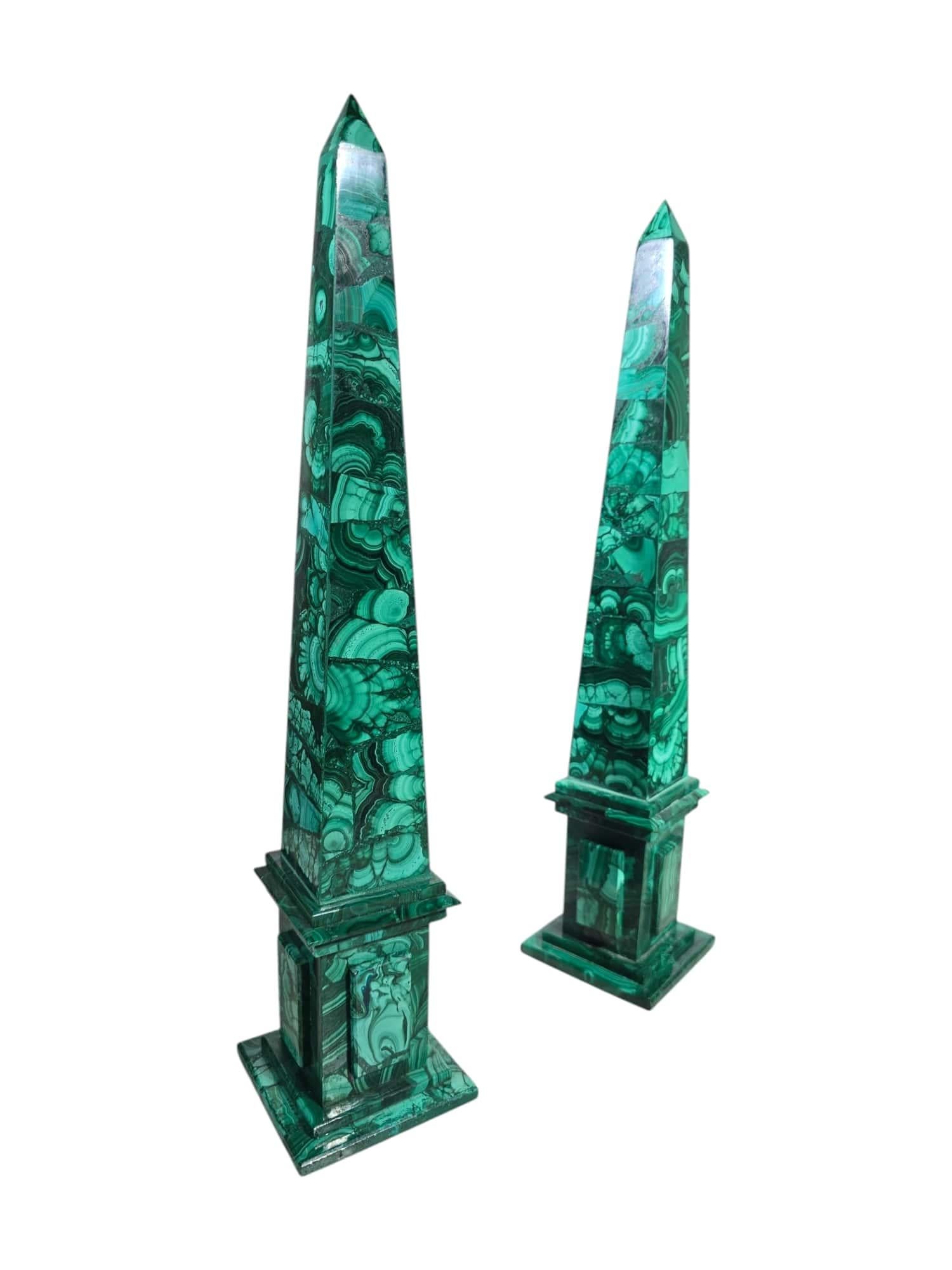 Questa elegante coppia di obelischi di malachite, realizzati negli anni '50, mette in mostra la bellezza senza tempo e i motivi sorprendenti di questa lussuosa gemma verde. Gli obelischi presentano linee pulite e geometriche che mettono in risalto