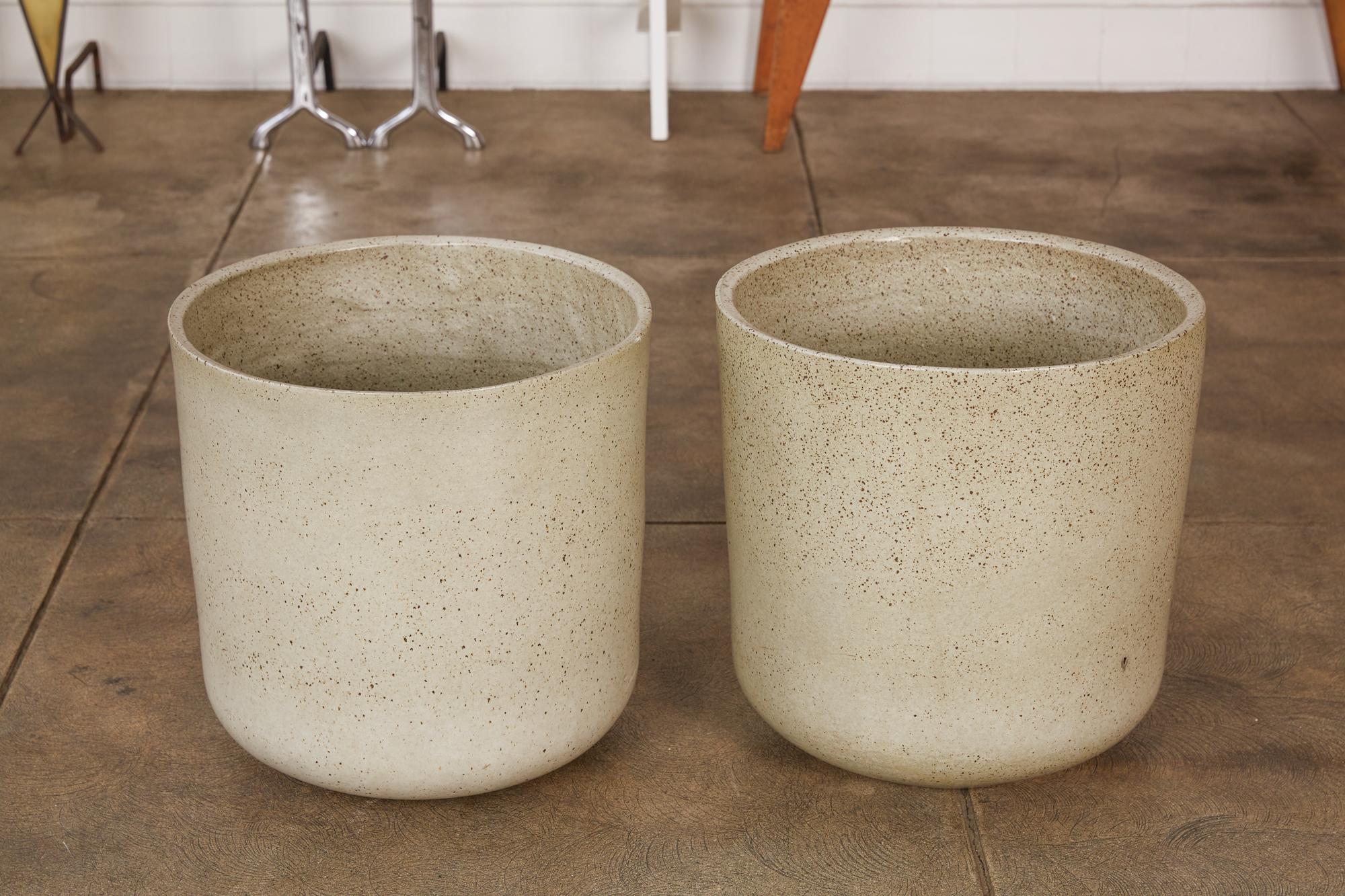 A pair of Malcolm Leland’s model LT-15 tall planters for Architectural Pottery. The pots feature a slightly flared cylindrical shape and a curved bottom, that is covered in a minimalist speckled glaze.

Dimensions: 17” diameter x 16.5”
