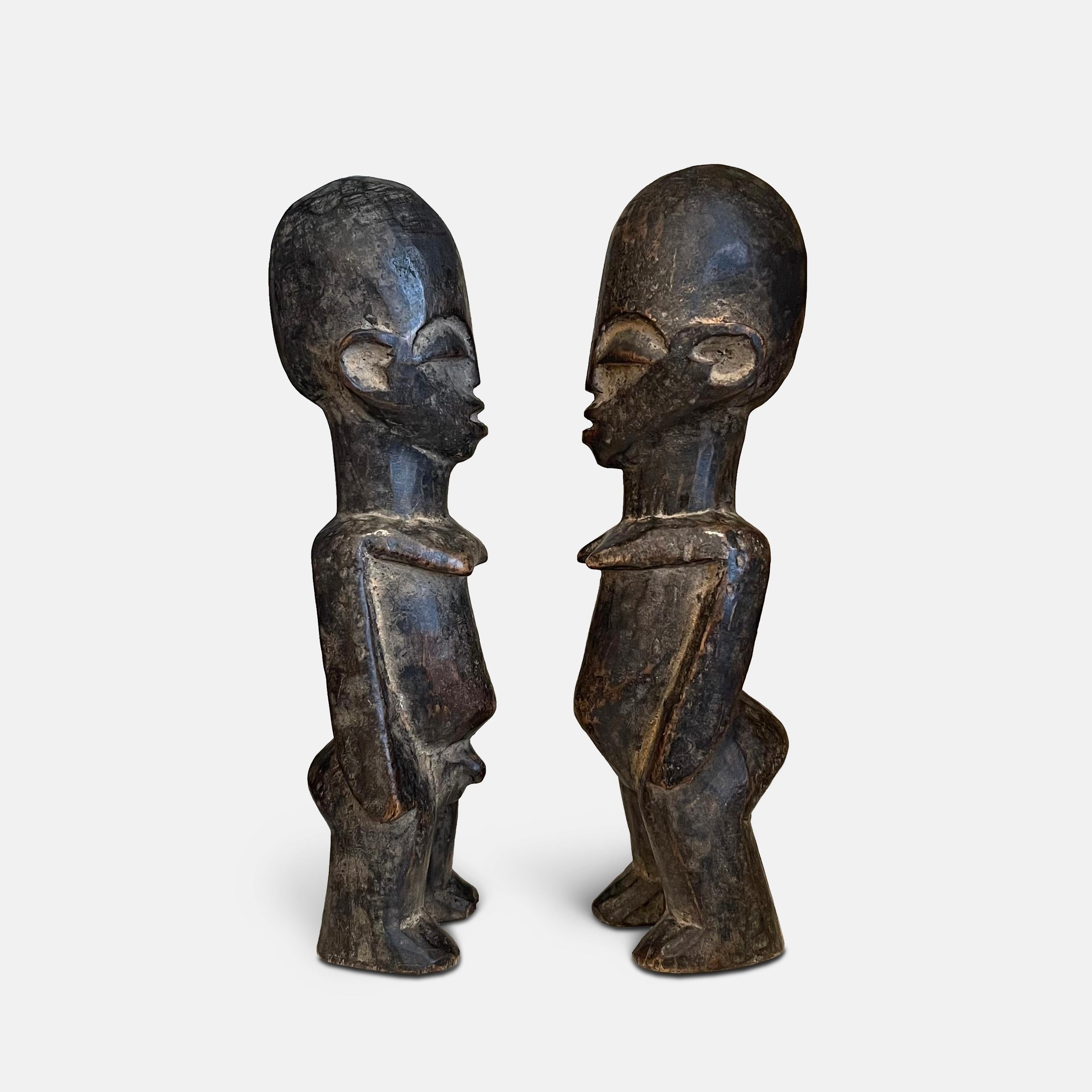 These paired statues, one male and one female figure, show a beautiful patina of use to the hard and dense wood. Made by the Lobi Birifor people of Burkina Faso, near the frontier with Ghana, they are a type of wooden carved figure known as