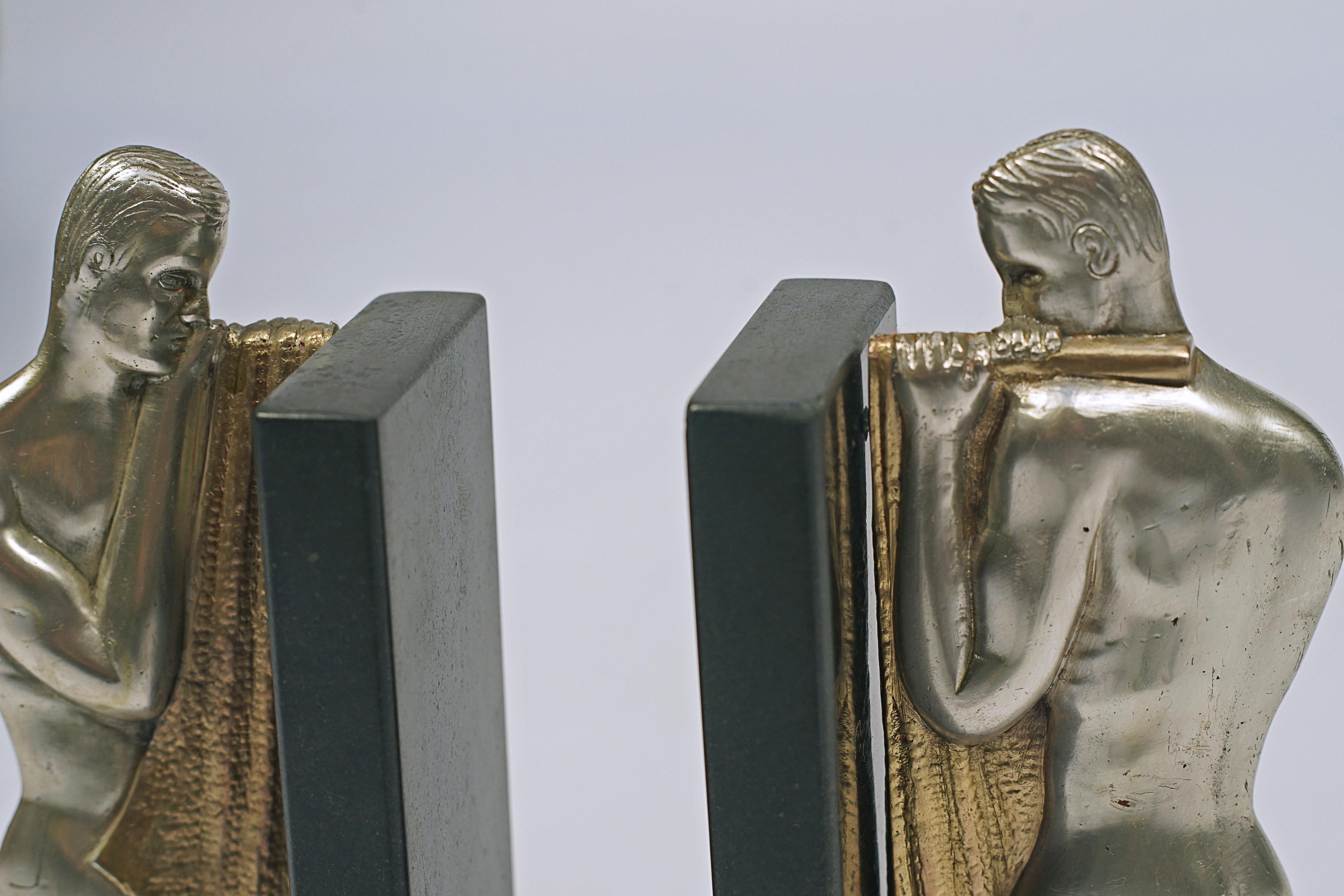 Paire de serre-livres à figures masculines. Bronze argenté avec détails dorés et base en marbre.

France, CIRCA 1930.