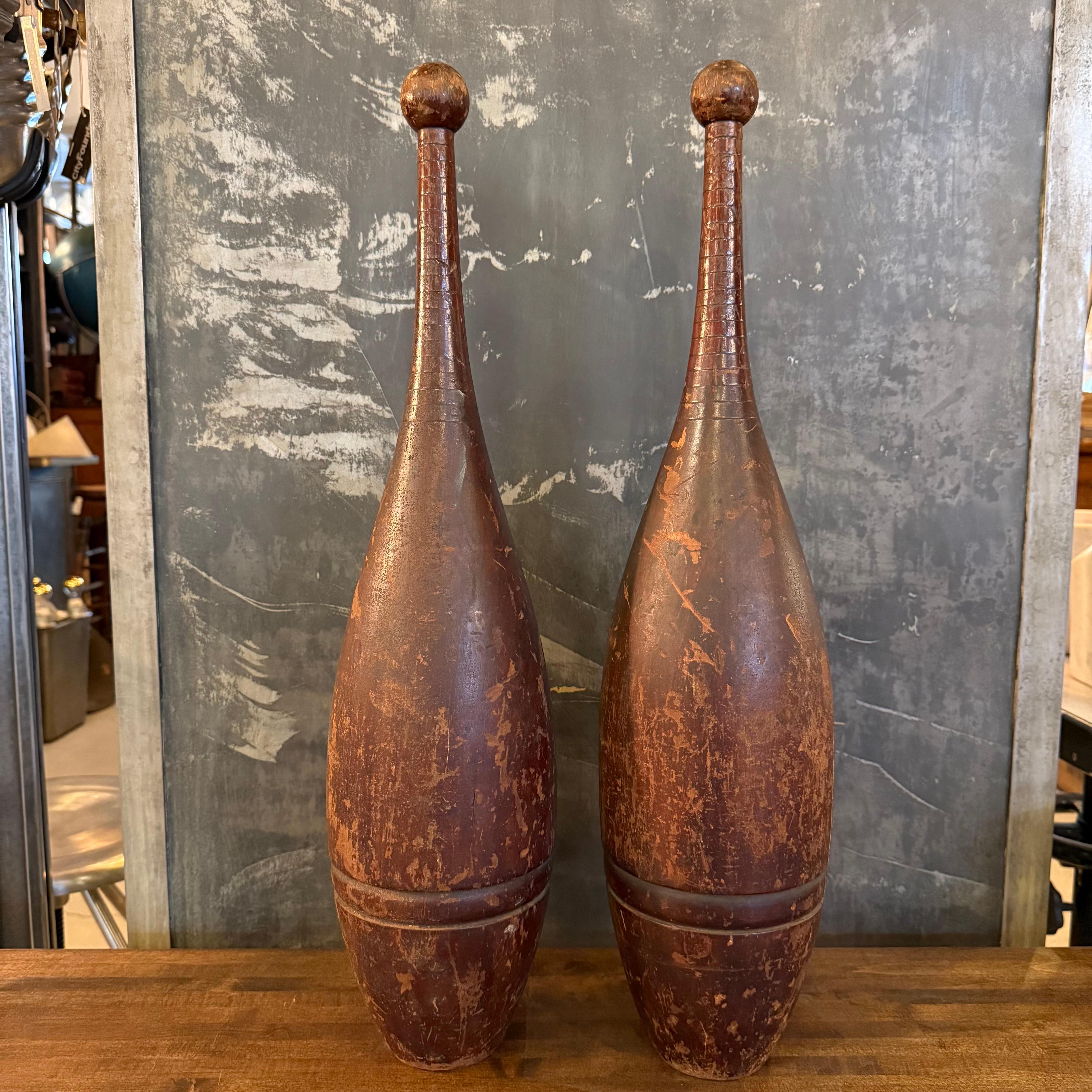 Cette paire de massues indiennes anciennes tournées à la main, également appelées épingles à jongler, présente une silhouette élancée en forme de goutte d'eau et une patine d'ancienneté remarquable. Les poignées de ces clubs sont particulièrement