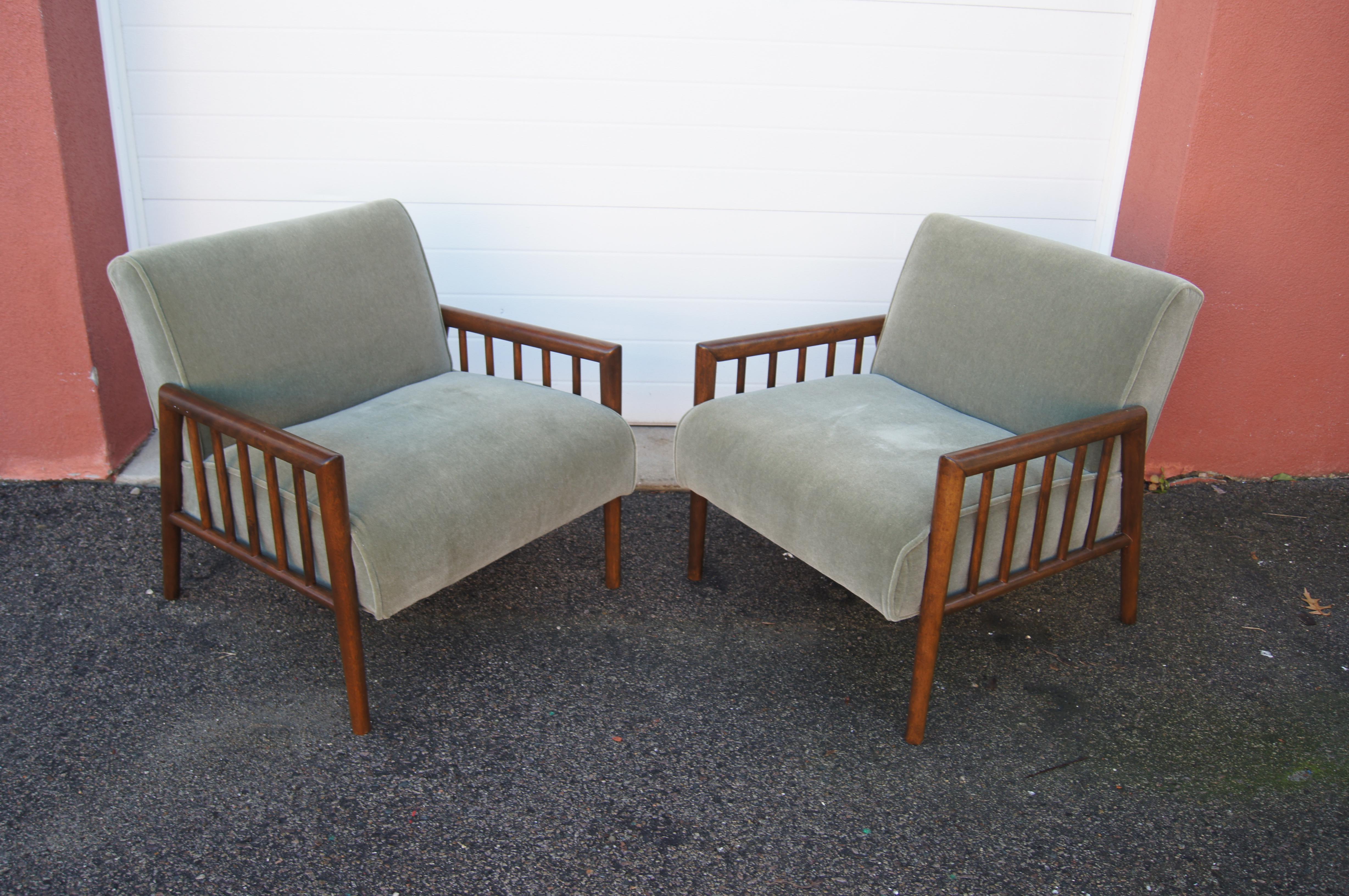This handsome pair of mid-century lounge chairs by Conant Ball, attributed to Leslie Diamond, features slat-sided frames of a warm-toned maple. Contrasting with the strong angled lines of the solid wood are capacious seats upholstered in a subtle