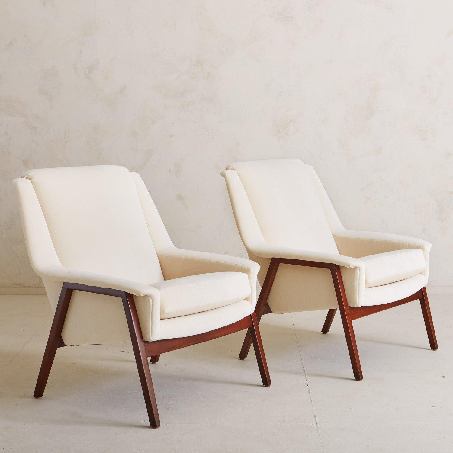 A timeless pair of accent chairs sourced in Italy, 1950s. These chairs feature angular seats freshly reupholstered in a white cotton velvet, which contrast beautifully with the stained maple frames.