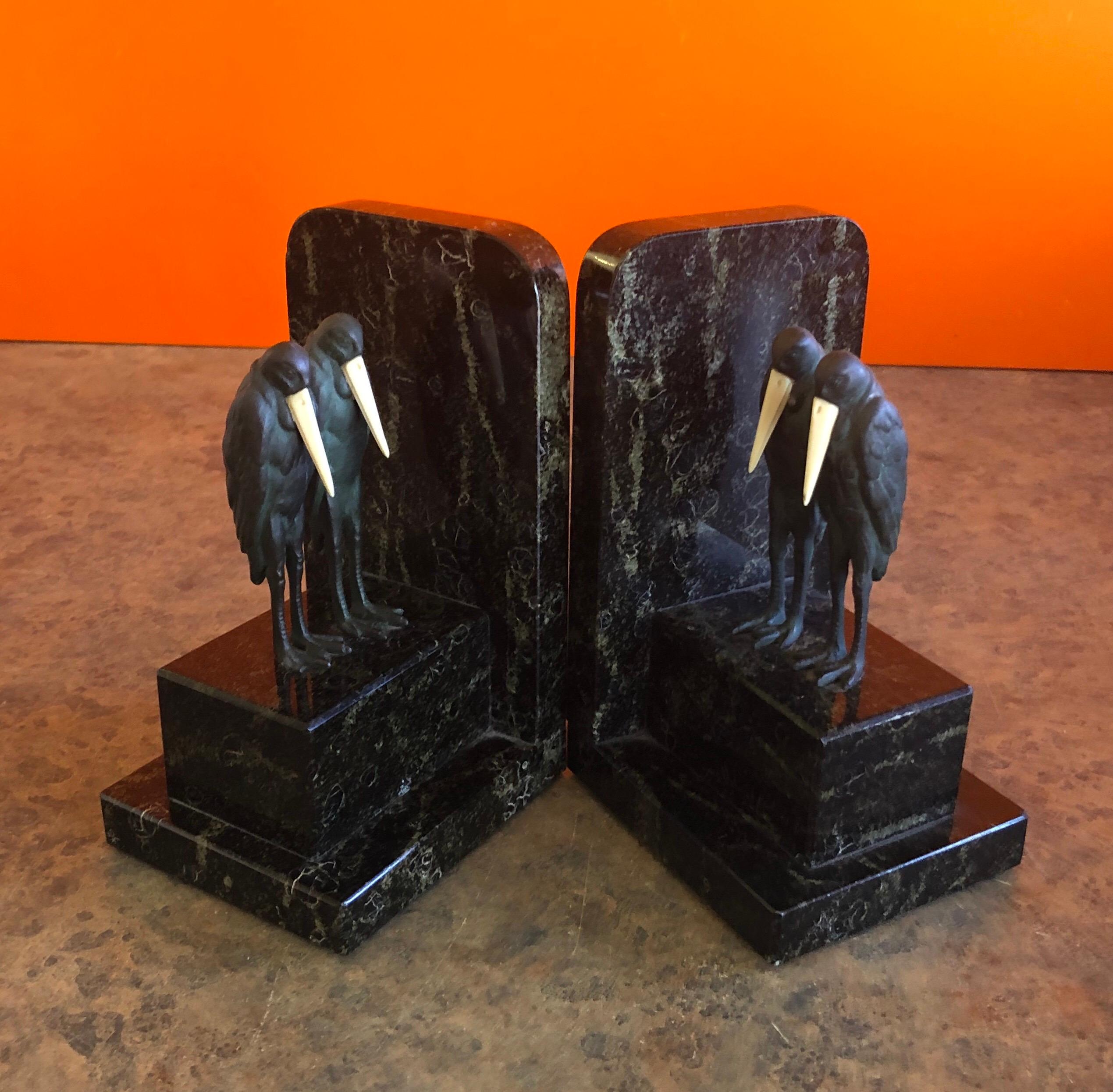 Gorgeous pair of Marabou Stork Art Deco bookends in the style of Marcel-Andre’ Bouraine, circa 1930s. The bookends are made of solid black with green veined marble with four cast bronze stork figures in the “Vienna Bronze” style, each has an applied