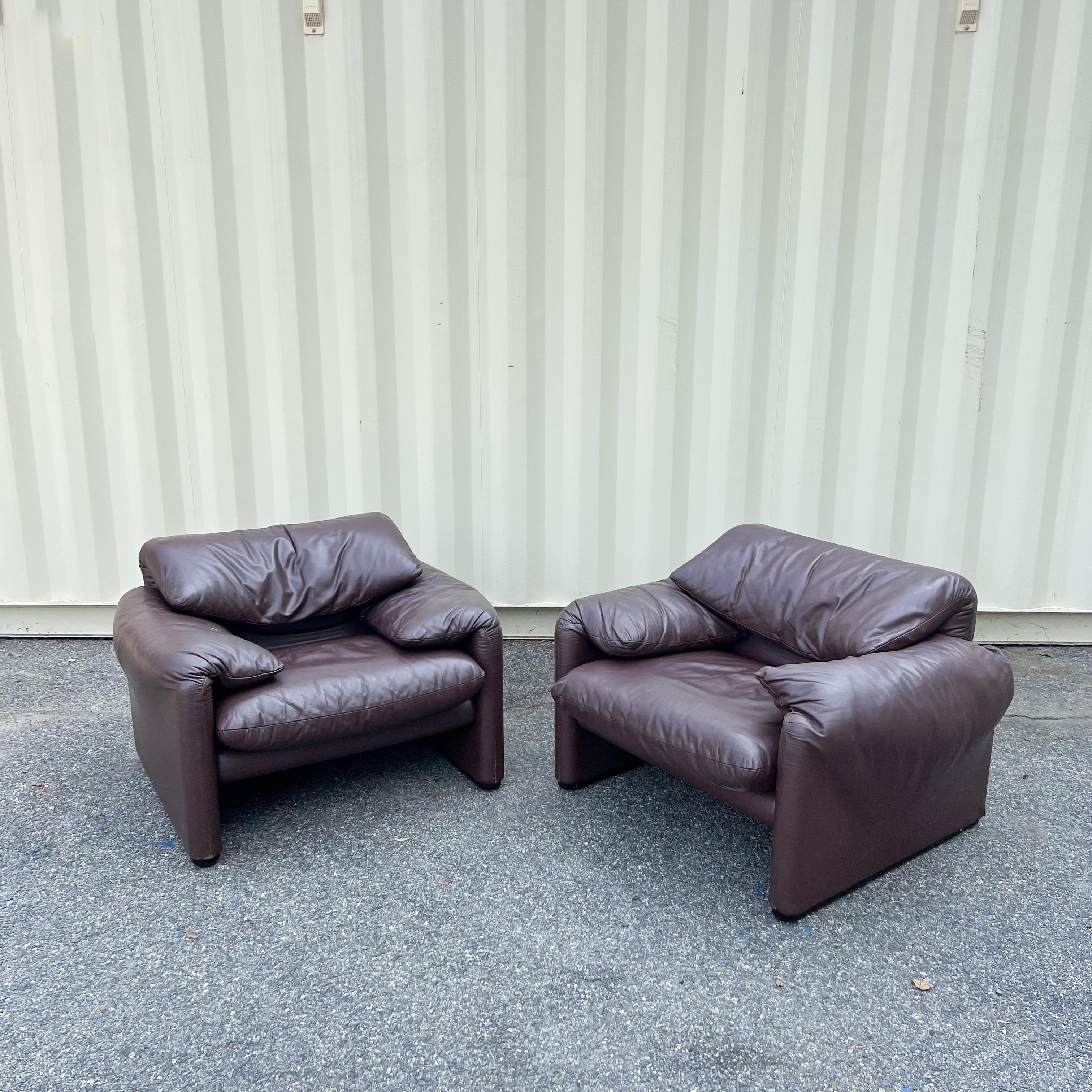 Pair of Vico Magistretti's 1973 Maralunga chairs for Cassina. Featuring the original brown leather upholstery. Some light scuffing/scratching to the leather. These chairs provide a comfortable deep seat with low armrest and have adjustable backrests