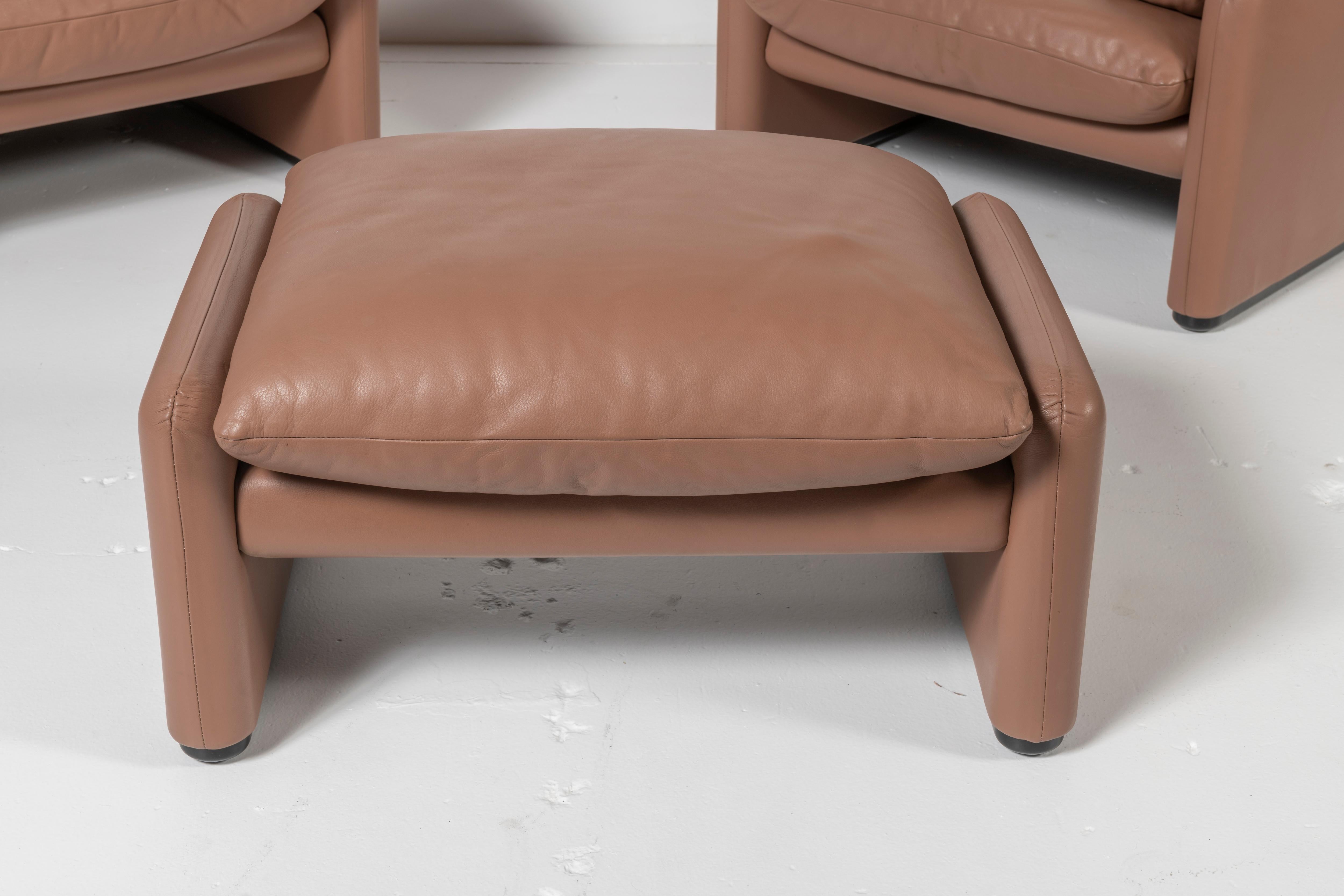 Super comfortable pair of Maralunga lounge chairs with ottoman in an unusual shade of tan leather. The chairs have an adjustable headrest and were designed by Vico Magistretti for Cassina. Ottoman completes the set. Lovely patina on the leather.