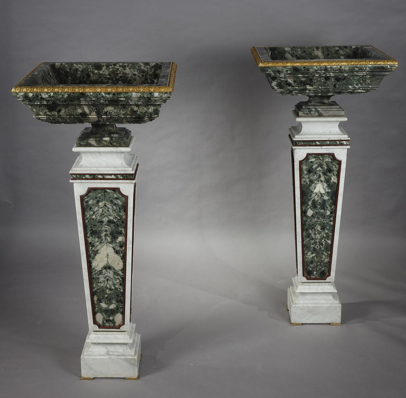 Measures: Height : 29 cm (11,4 in.) ; width : 61,5 cm (24,2 in.) ; depth : 55,5 cm (21,8 in.)
Total height : 139 cm (54,7 in.)

Important pair of rare Greek antique green marble basins with molded decoration framed by a leafy frieze in gilded