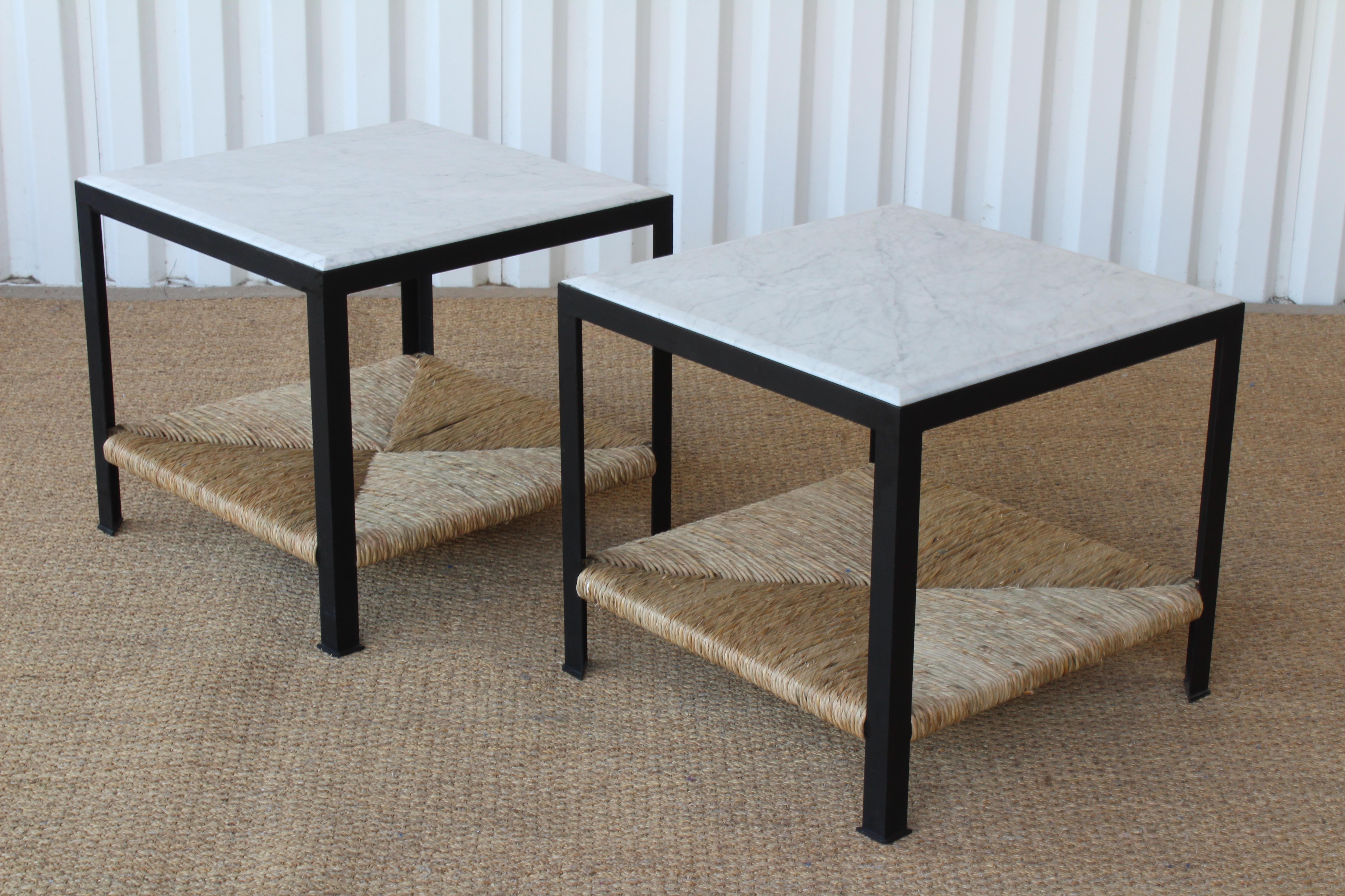 Pair of custom made steel framed end tables with marble tops and woven rush bottom shelves. Each end table is made of solid steel in a satin black powdercoated finish. The tops are beveled Italian marble. Each table was handwoven with rush bottom