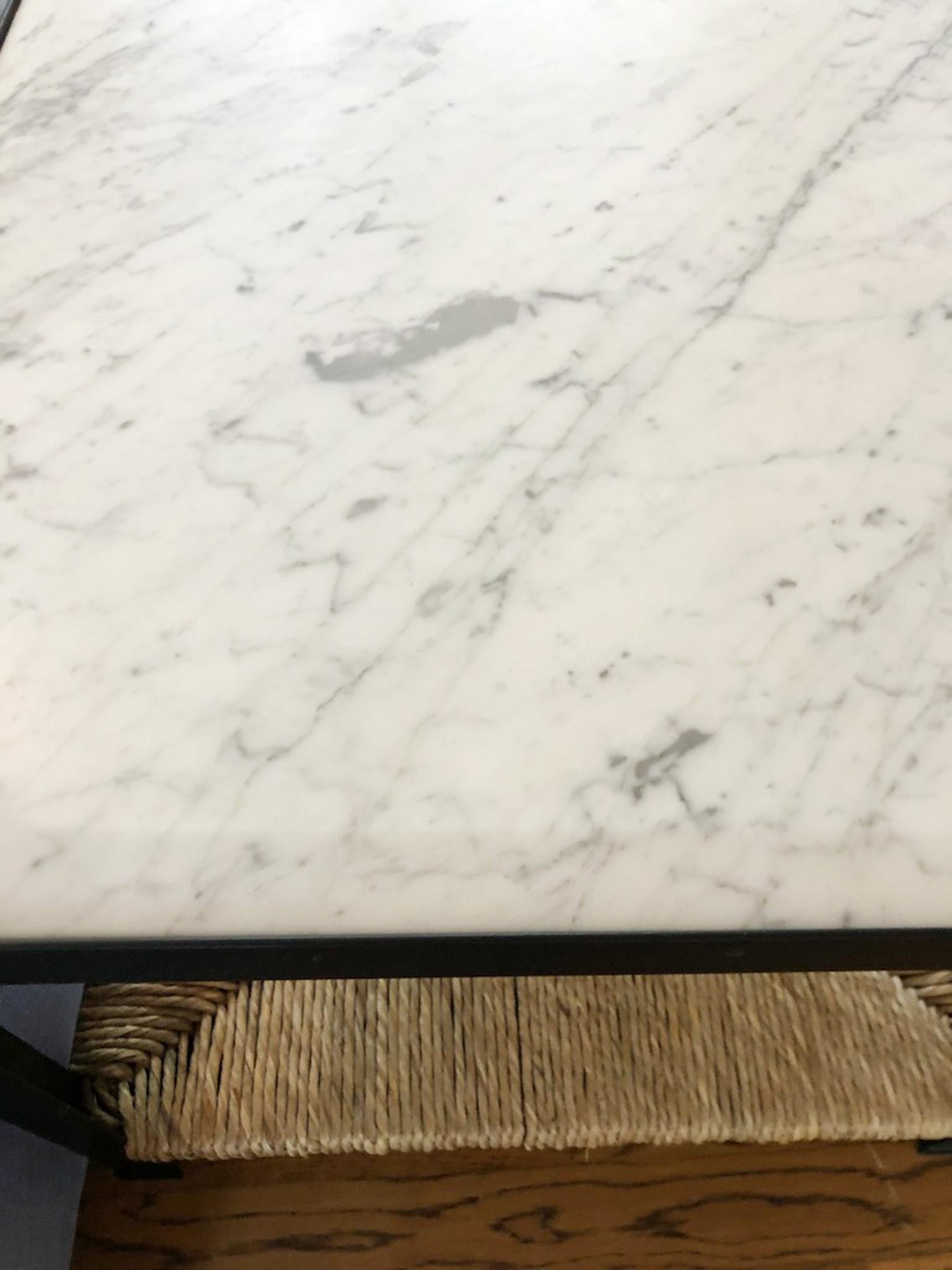 Zwei maßgefertigte Beistelltische mit Stahlrahmen, Marmorplatten und gewebten Binsenböden. Jeder Beistelltisch ist aus massivem Stahl gefertigt und satinschwarz pulverbeschichtet. Die Platten sind aus abgeschrägtem italienischem Marmor. Jeder Tisch