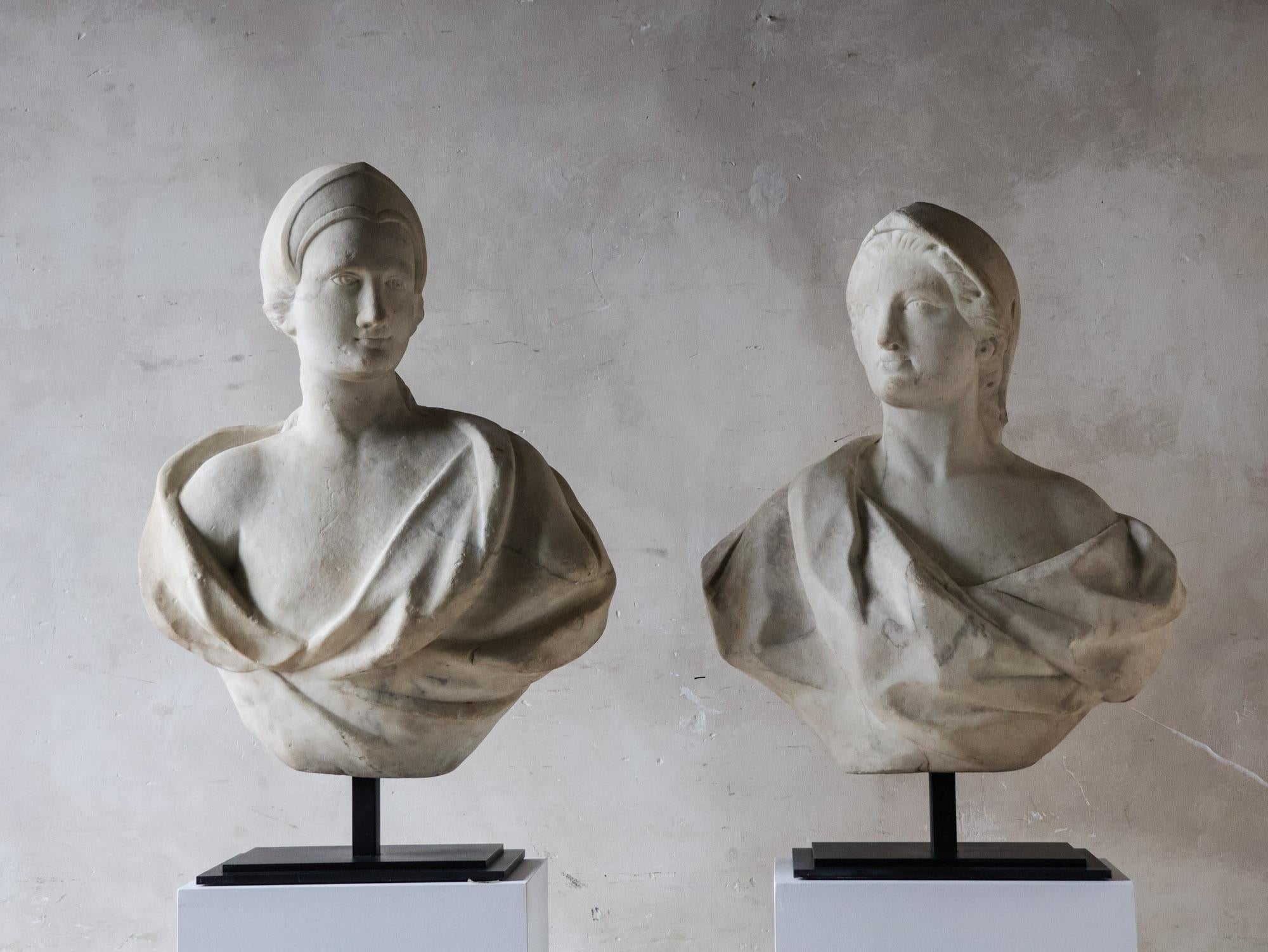 Pair of marble busts, Italy, c. 1690, carrara marble. This pair of busts, made of Carrara marble, depicts a god and a goddess. Both are dressed in a tunic that drapes over their shoulders. The goddess is shown with one breast exposed, in classical