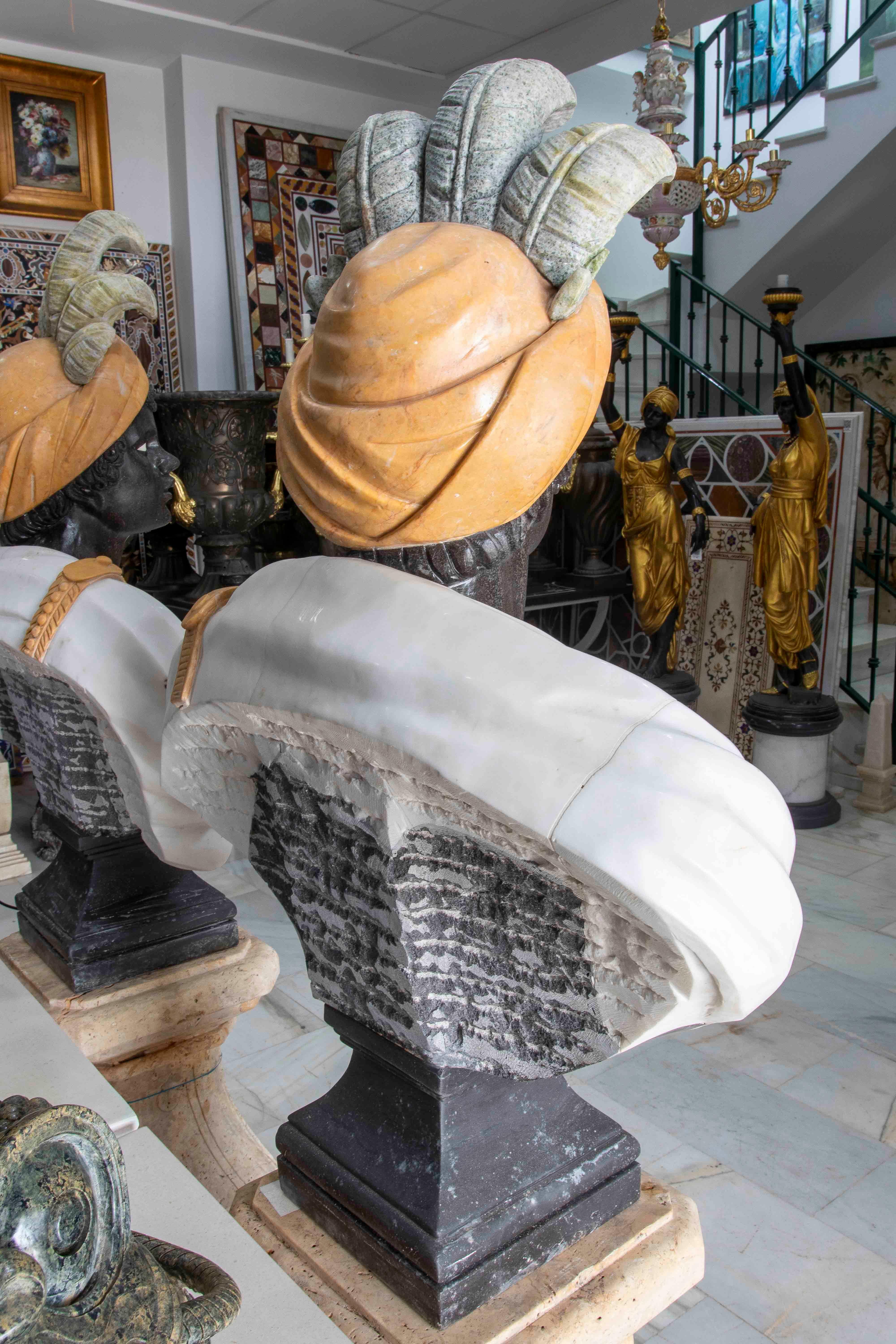 Hand-Carved Pair of Marble Busts of Warriors with Hats and Feathers For Sale