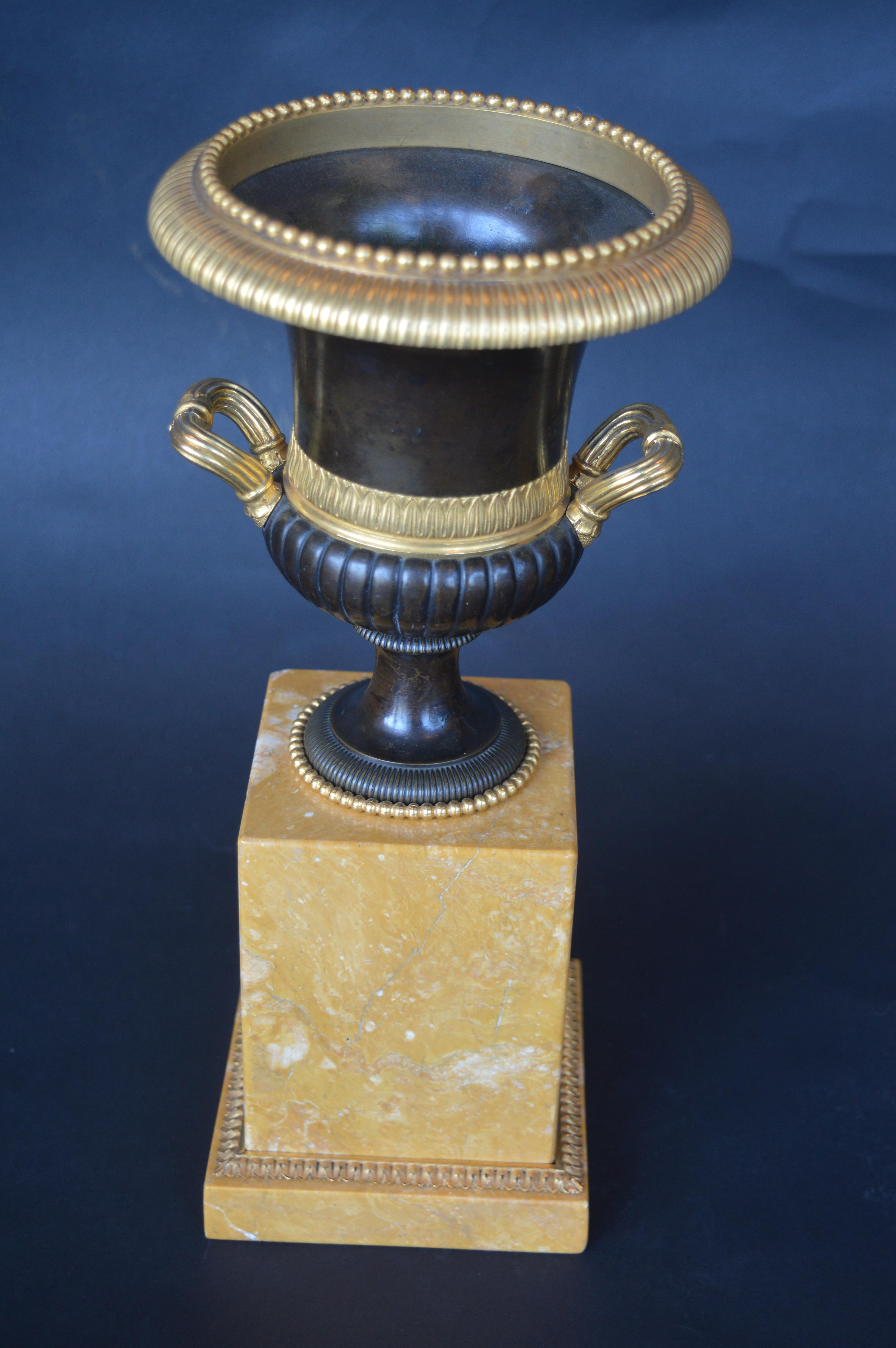 A pair of gilt, patinated bronze and marble campagna urn ornaments.