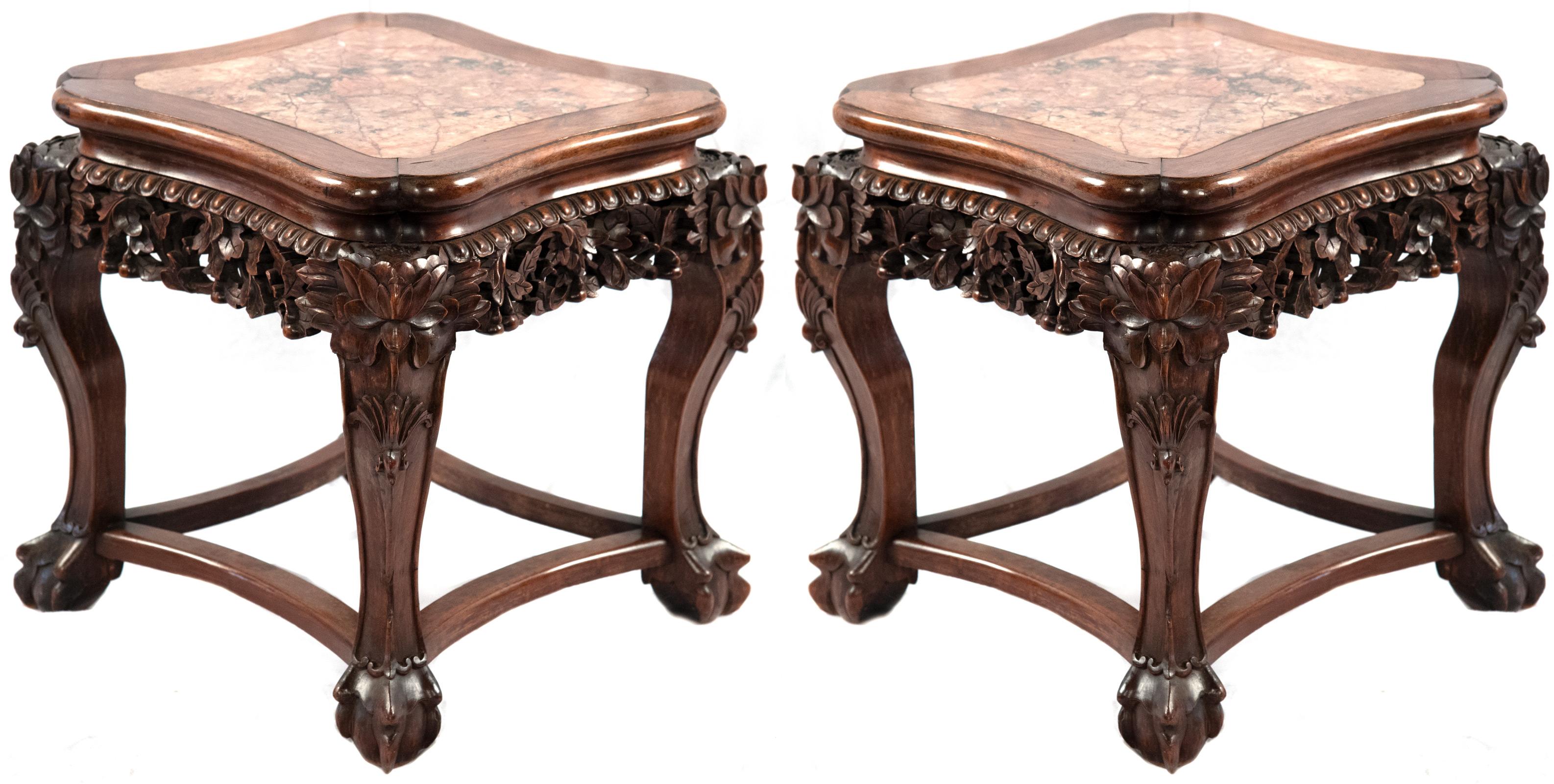 Two carved hardwood stands with dragon claw feet clutching sacred pearls with inlaid marble tops.