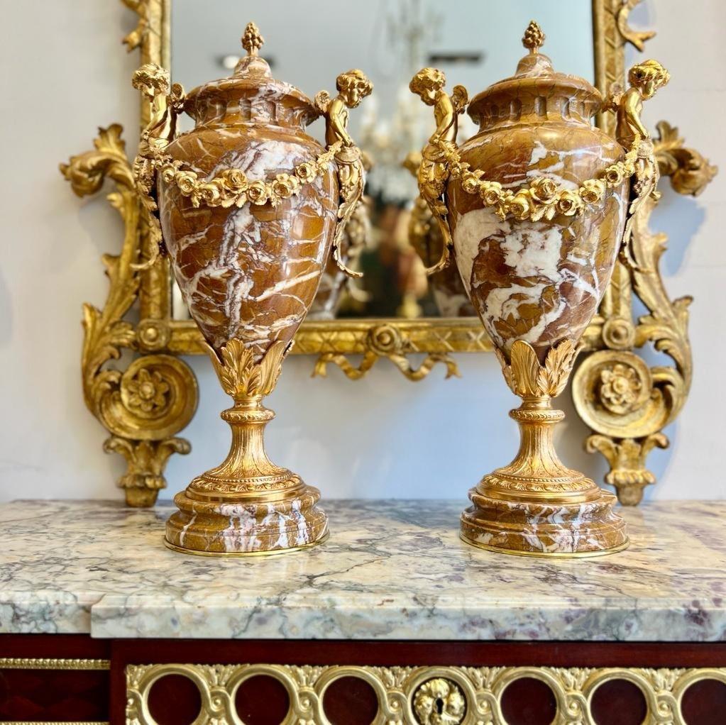 Magnifique paire de grandes cassolettes de style Louis XVI en marbre brun clair veiné de blanc, d'époque Napoléon III. Rares par leur taille (56 cm de haut), elles sont aussi équilibrées grâce à l'association harmonieuse de l'ocre au marbre blanc et