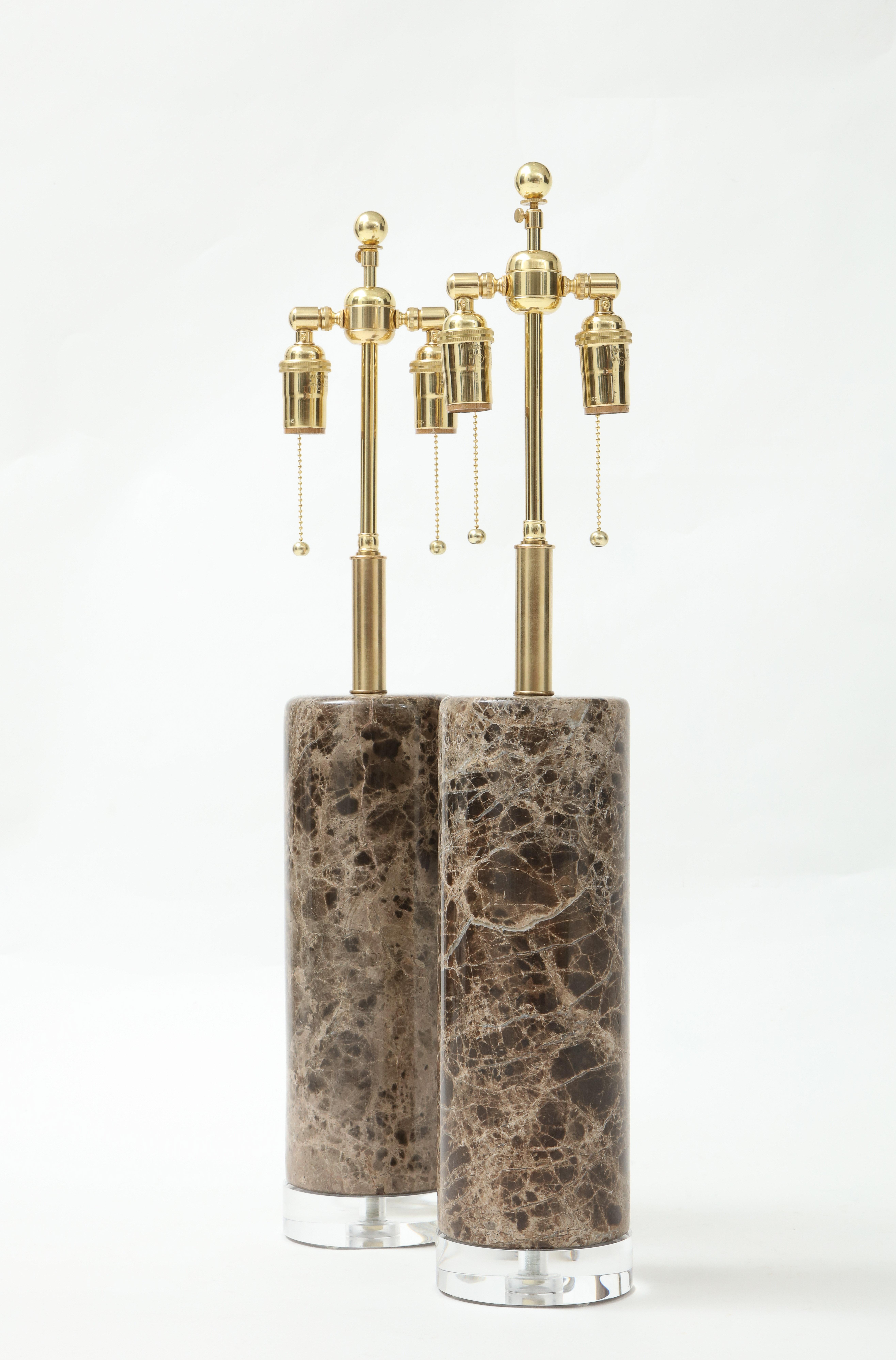 Coppia di lampade cilindriche in marmo che poggiano su spesse basi in lucite.
Le lampade sono state ricablate di recente con doppi gruppi regolabili in ottone lucido.
