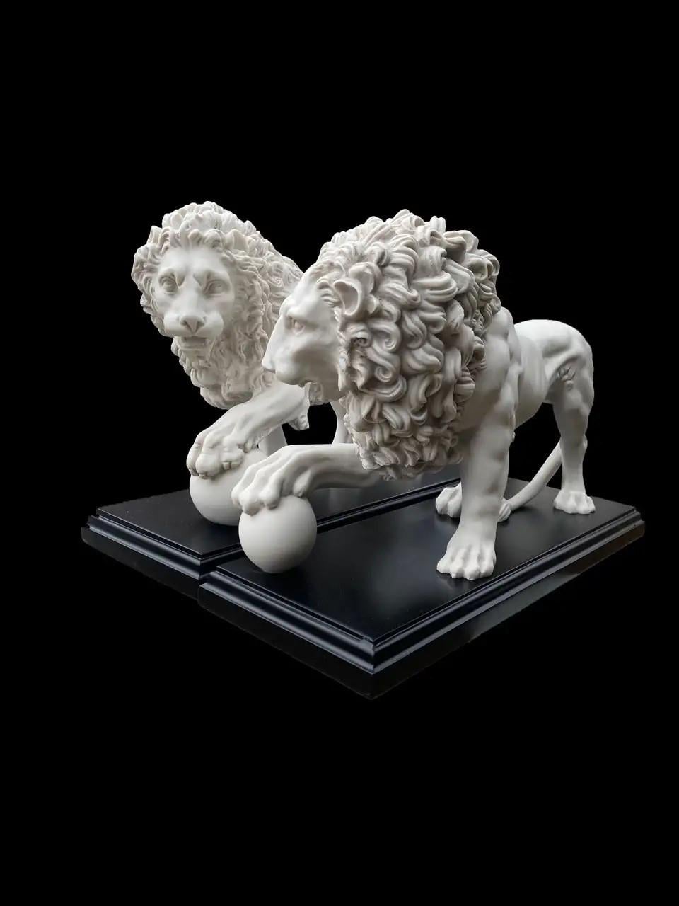 This is a beautifully sculpted pair of decorative composite marble lions with balls from the originals at Villa Medici, Rome, dating from the last quarter of the 20th century.

They feature well sculpted definition to the body and mane. The