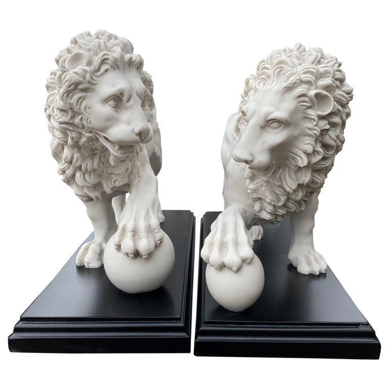 This is a beautifully sculpted pair of decorative composite marble lions with balls from the originals at Villa Medici, Rome, dating from the last quarter of the 20th century.

They feature well sculpted definition to the body and mane. The
