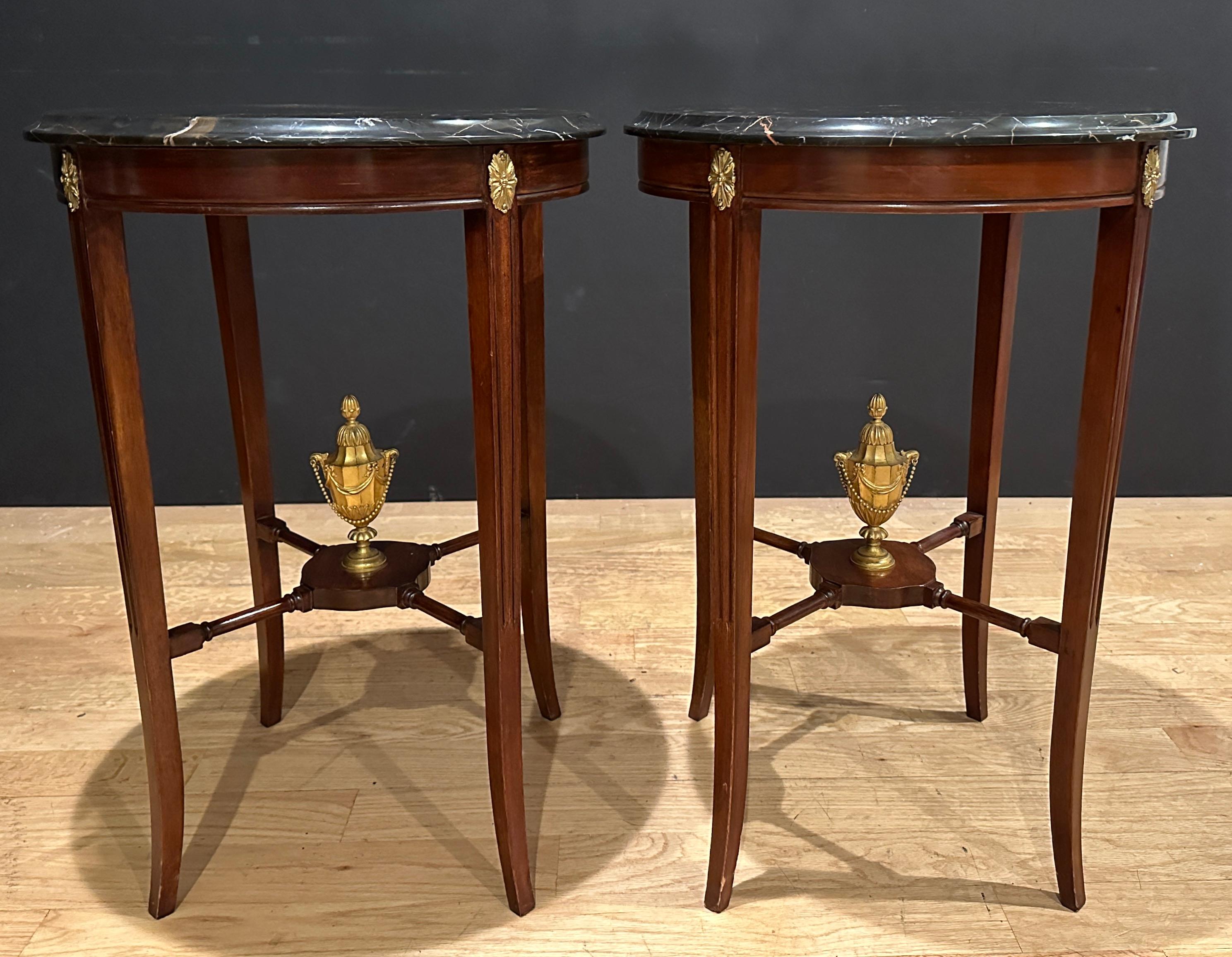 Fine quality, tailored and elegant pair of black variegated marble top bronze mounted end/side tables. Bottom stretcher mounted with bronze urns drapped with bows and ribbon, side chains and topped with acorn finials.