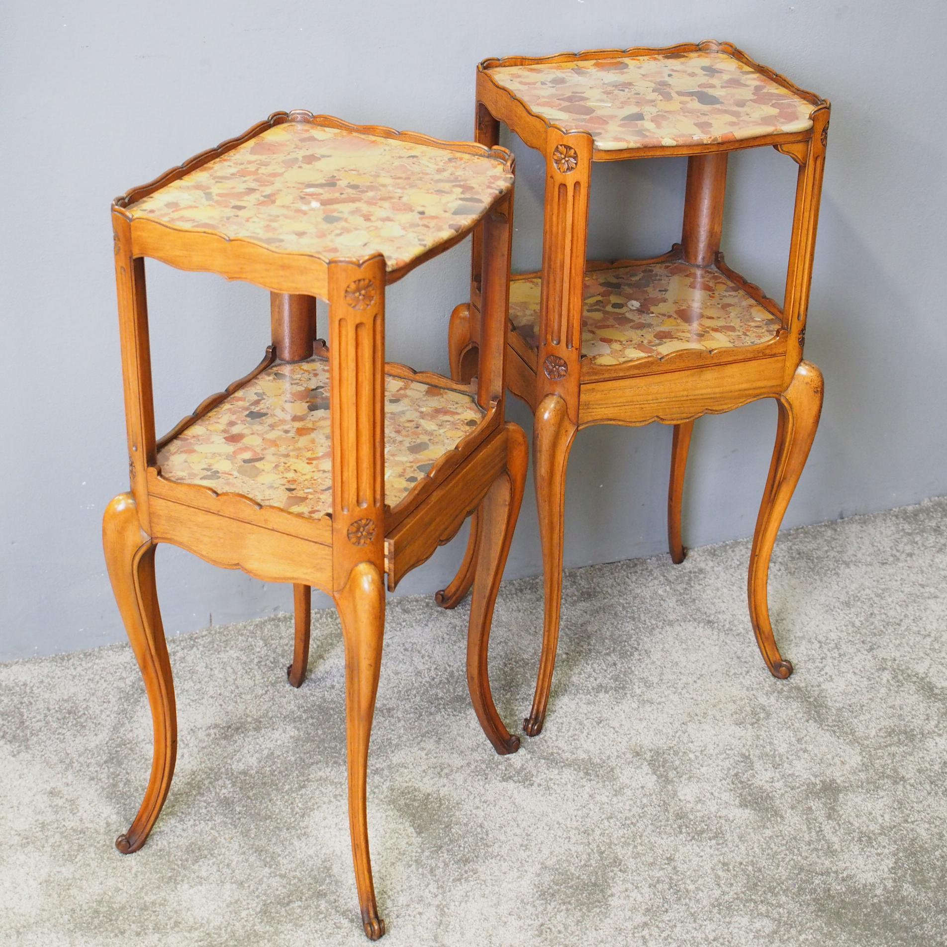 Pair of walnut two-tier bedside tables or étagères by Morison and Co of Edinburgh, circa 1890. With shaped three quarter gallery around a top of mottled pink marble, and a similar marble tier below this. These are connected by beaded uprights with