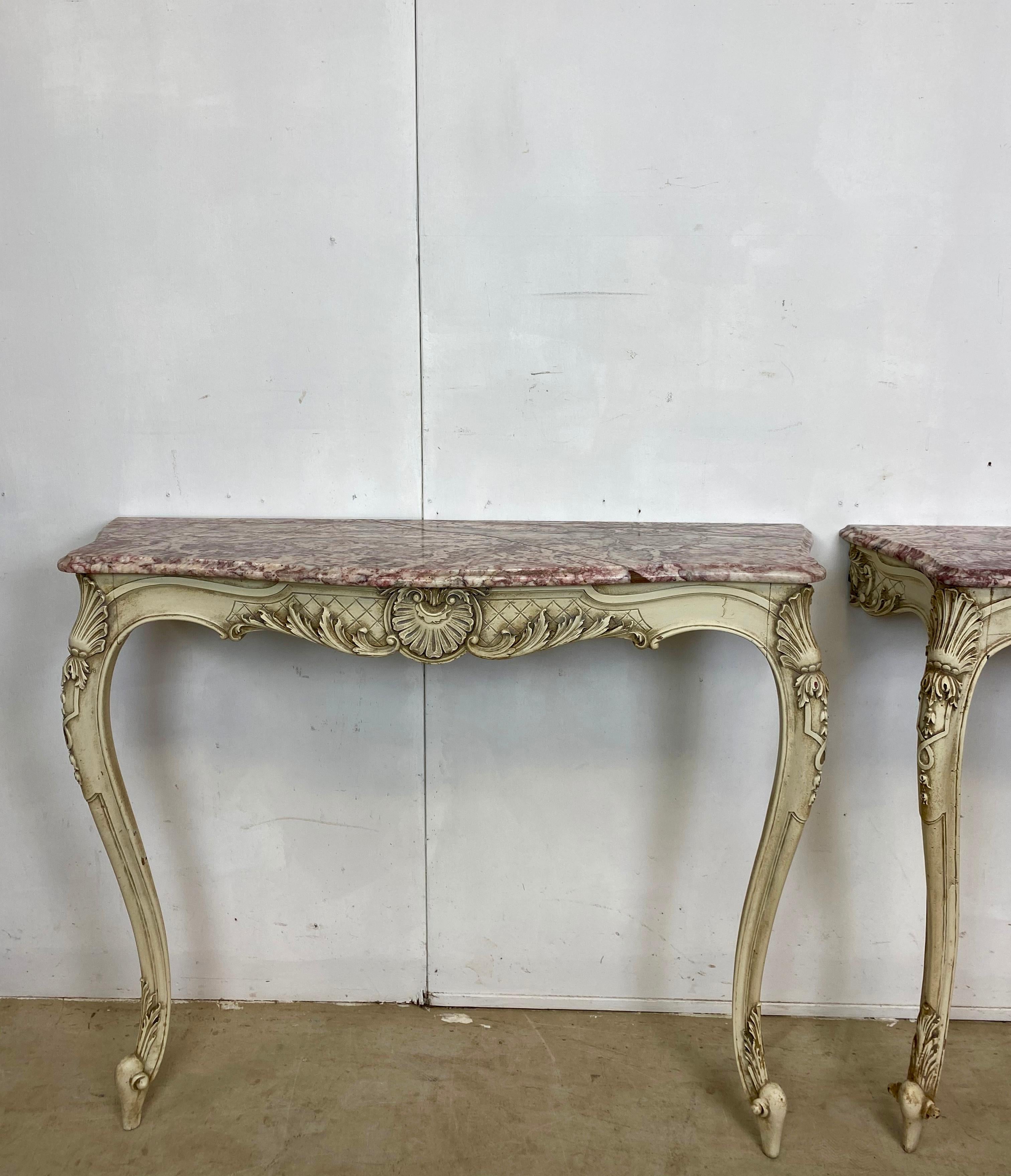 A pair of French console tables with rare and very attractive coloured marble tops. There is nice detail all over these tables. All in their original paint.