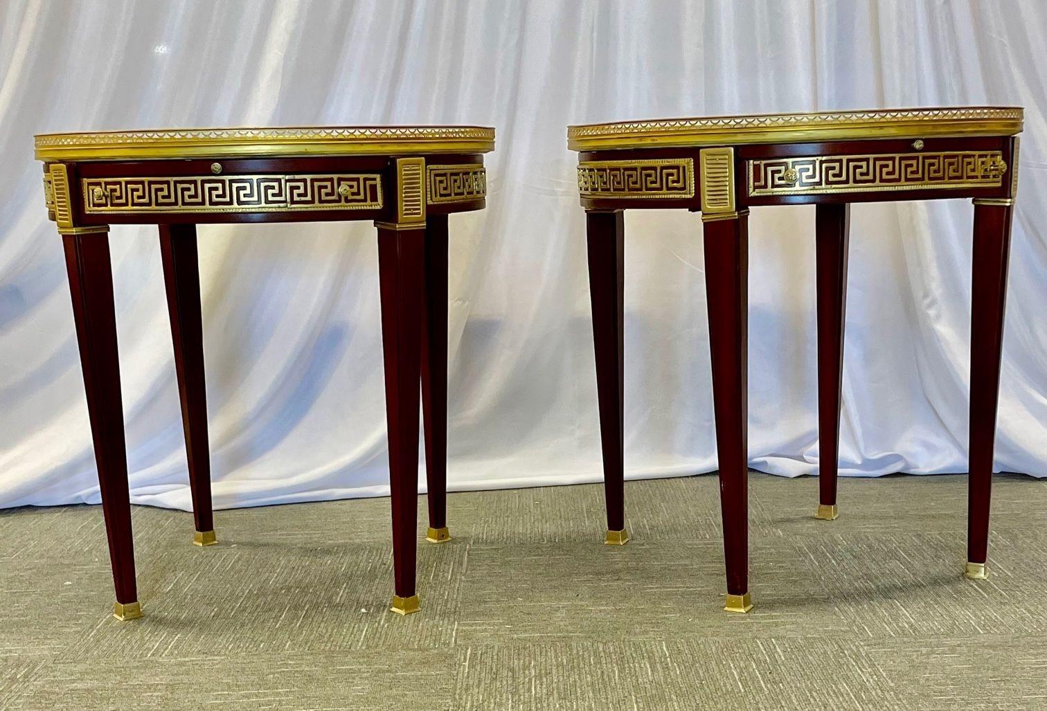 Pair of marble top greek key bouillotte or end tables, manner of Maison Jansen.
 
A pair of marble top Greek Key Bouillotte or end, side, lamp or center tables. Manner of Jansen in mahogany with double drawers and pull-out slides. Each bronze